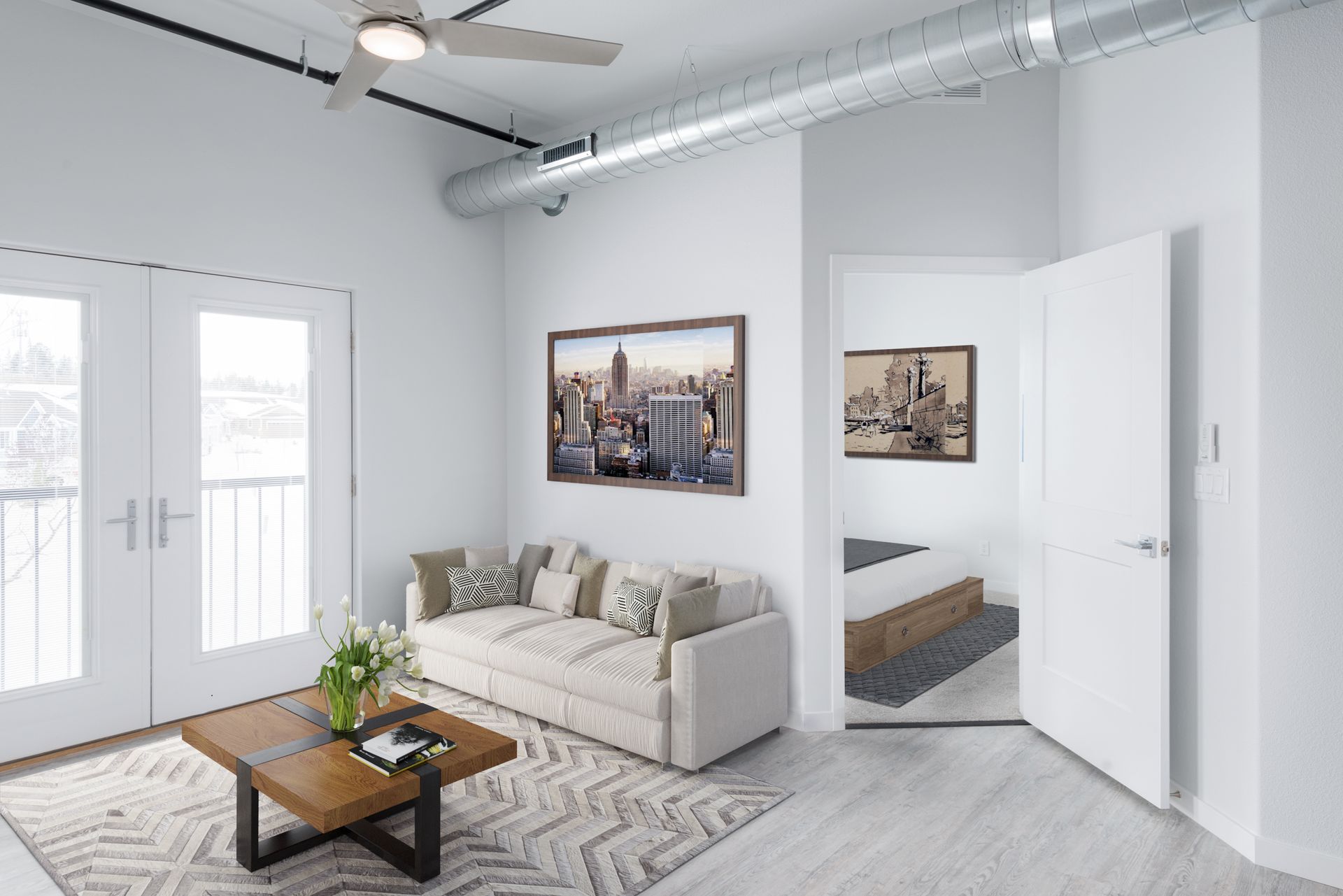 Bright modern living room with white sofa, coffee table, wall art, and mirrored closet doors