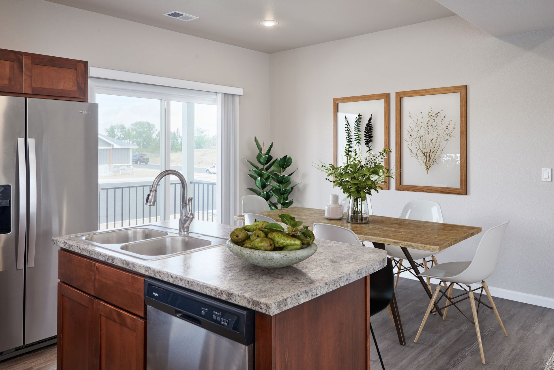 Modern kitchen with granite island, stainless appliances, and a small dining table by the window