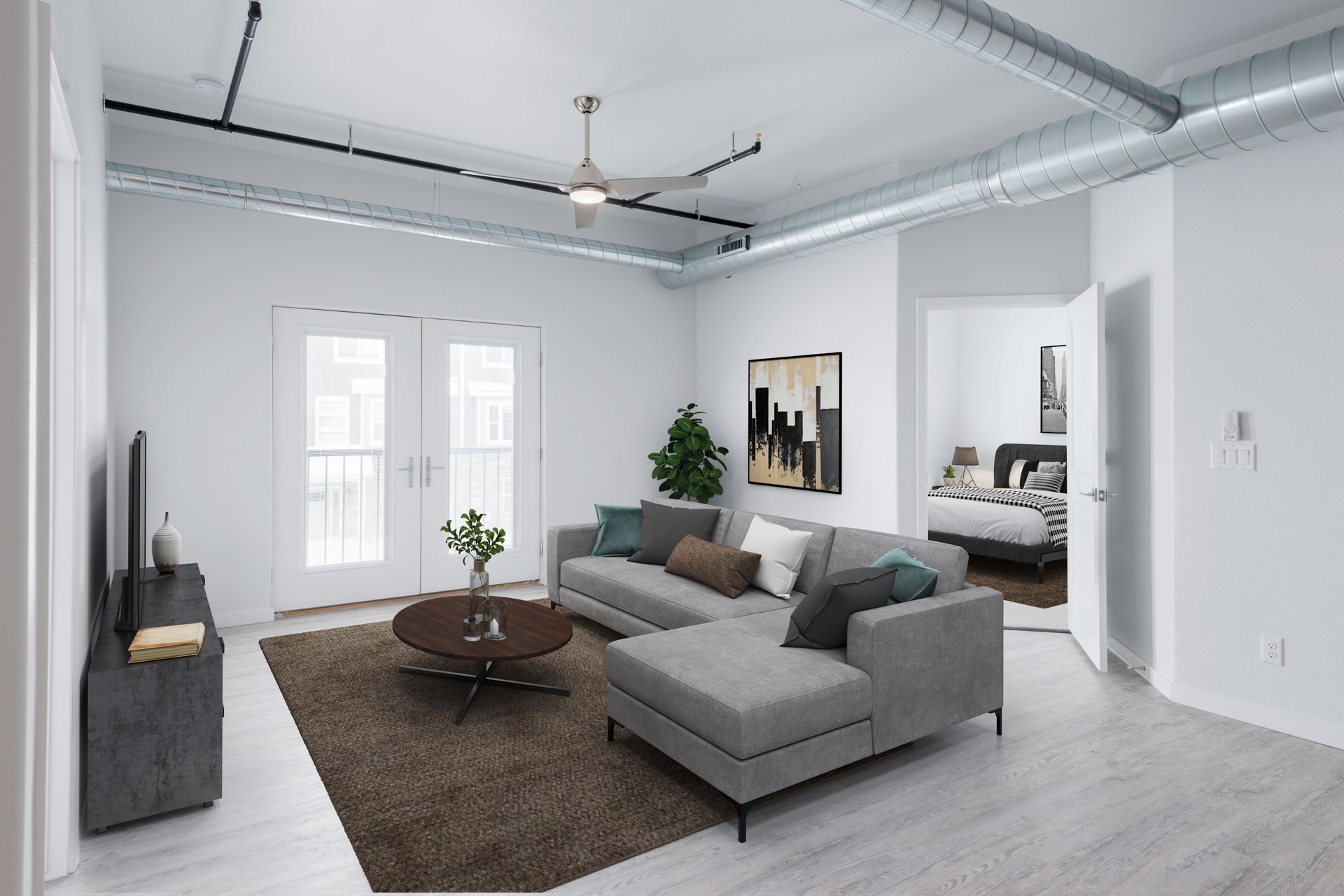Bright modern living room with gray sectional, coffee table, brown rug, and large windows