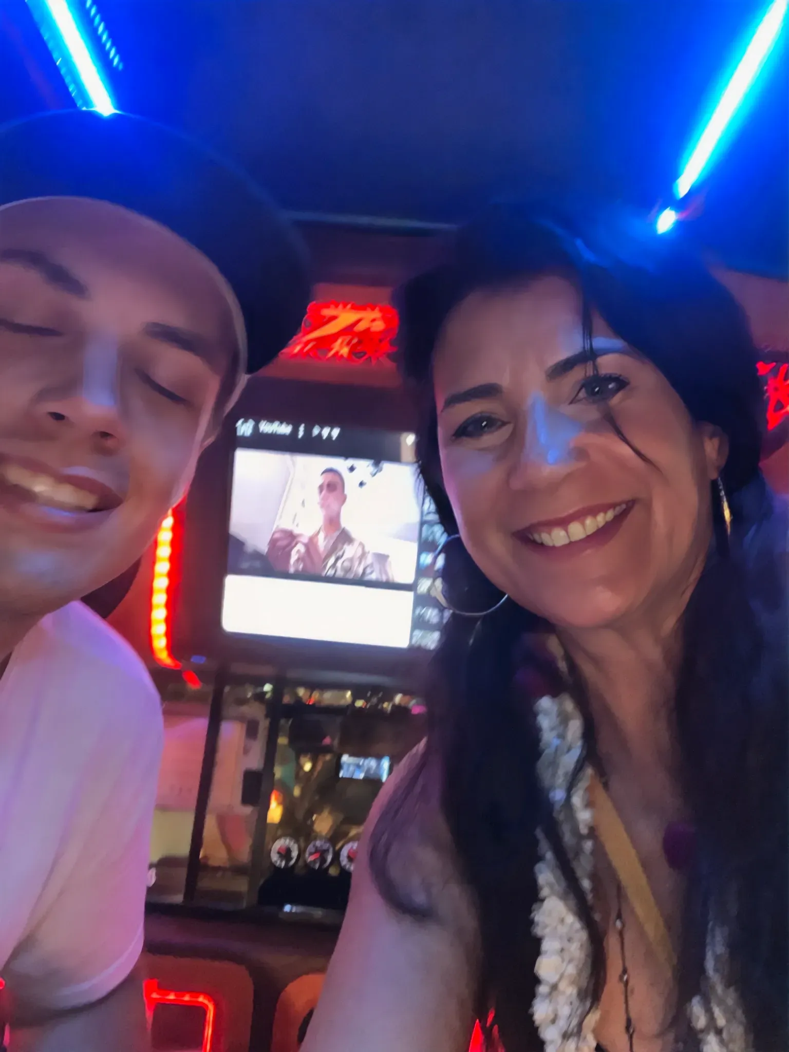 Paula and her son at a neon lit place in Phuket