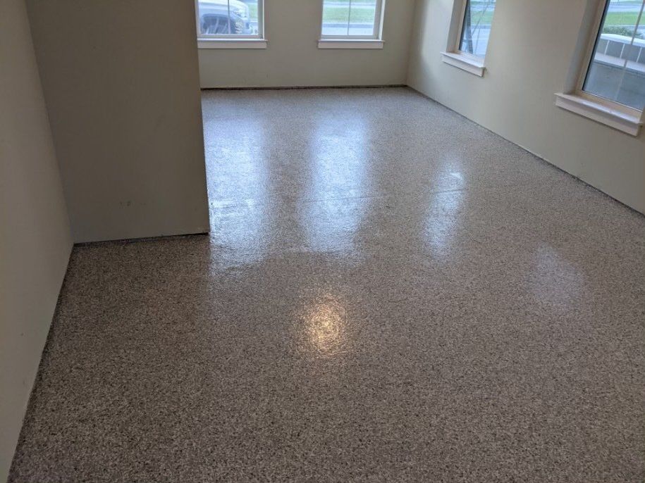 Room with polished concrete floor, beige walls, and three windows with white trim.