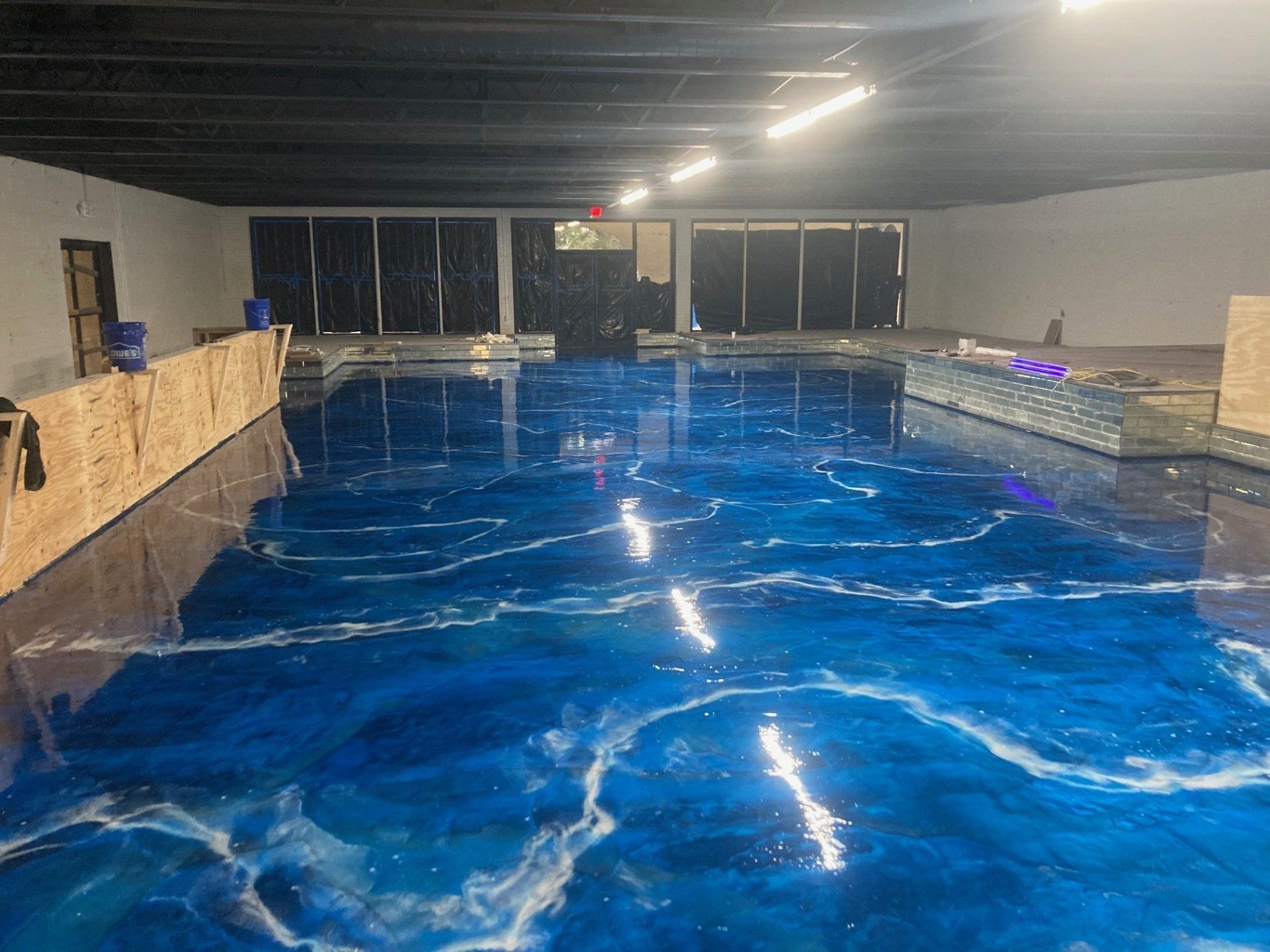 Blue and white epoxy floor with a wave design in a large indoor space.