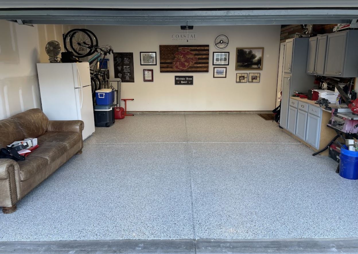 Open garage interior with a leather couch, refrigerator, and various decorations on the wall.