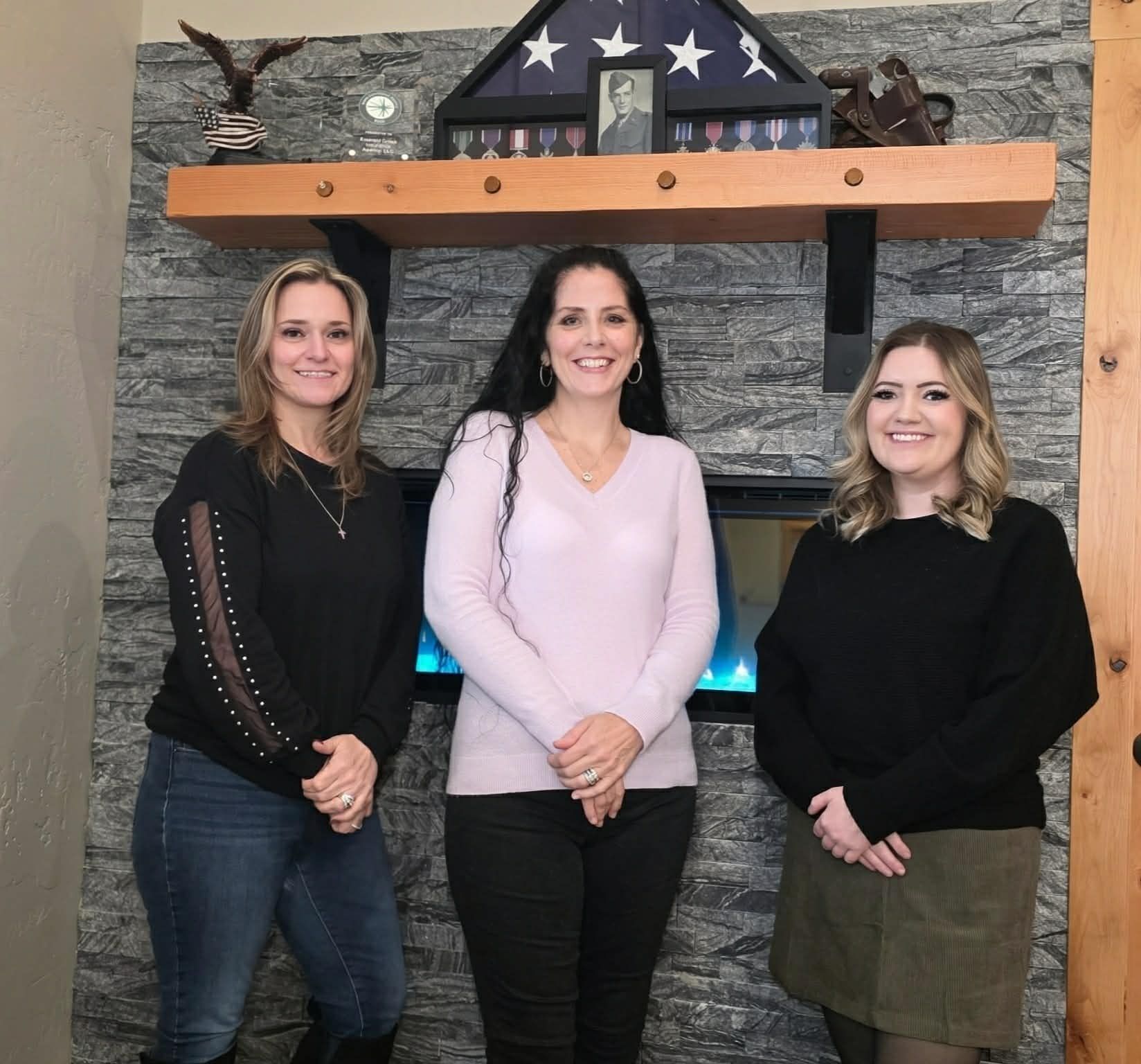 Mary and Brian Wade together with Ariel Mcguire and Brittany Nelson are posing in front of a fireplace.