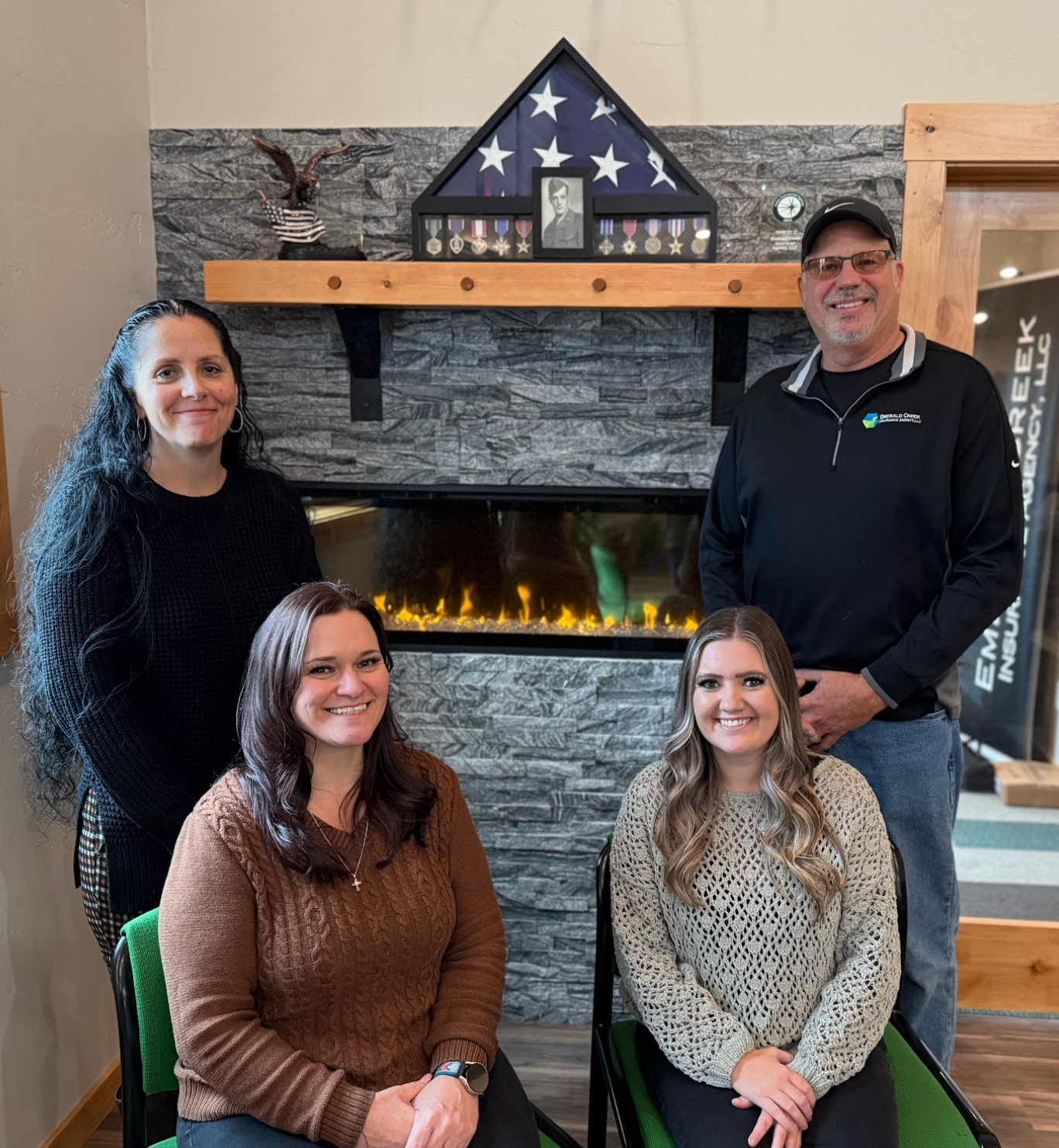 Mary and Brian Wade together with Ariel Mcguire and Brittany Nelson are posing in front of a fireplace.