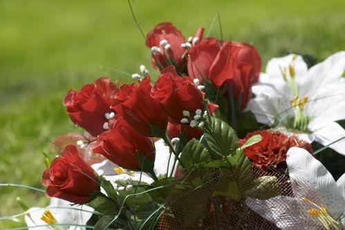 A bouquet of red roses and white lilies in a cemetery