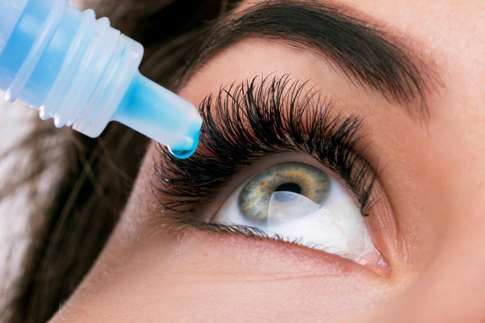 female patient using dry eye medication drops at Eye Associates of North Jersey