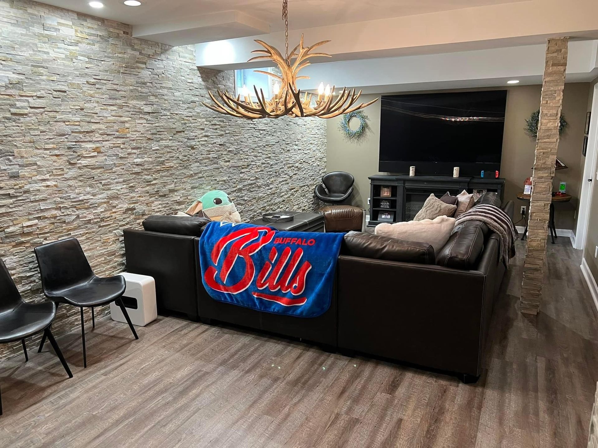 A living room with a couch , chairs , and a blanket that says bills on it.