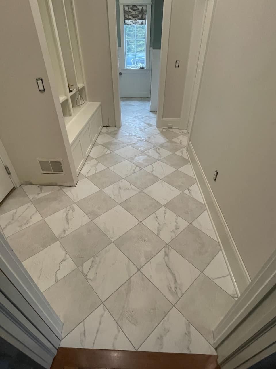 A hallway with white tiles and a checkered floor