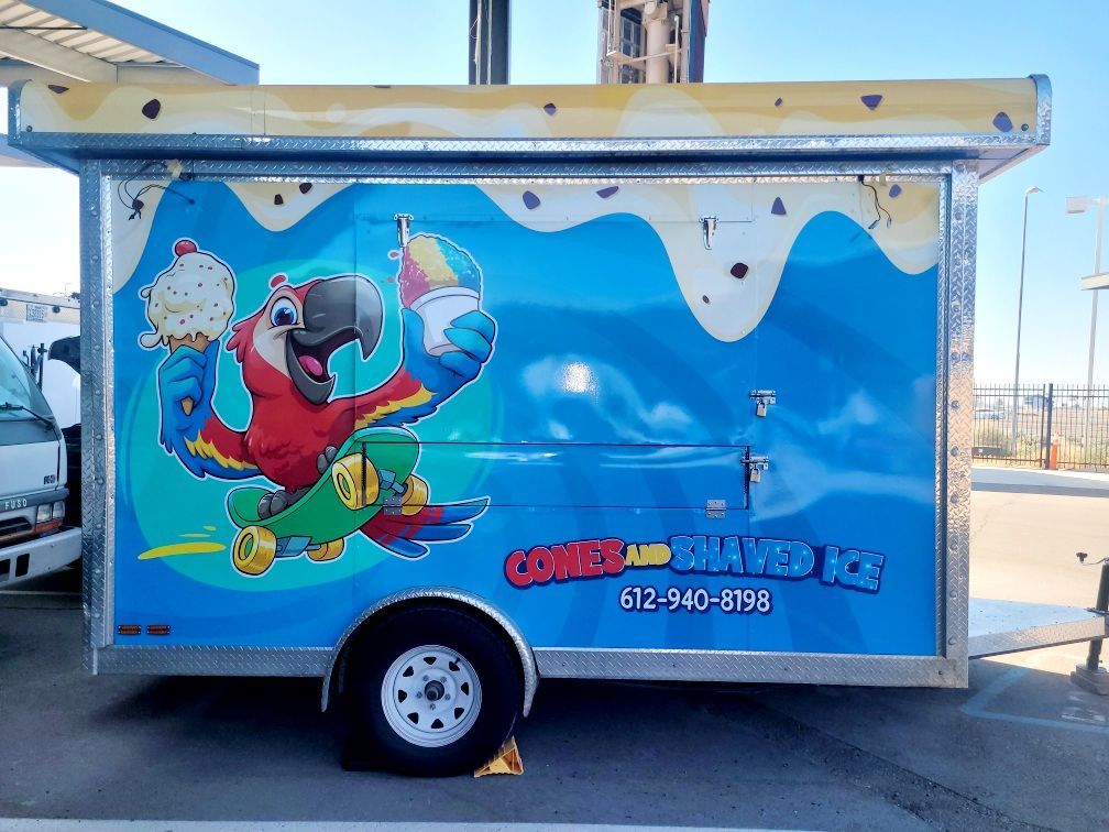 Snow cone and shaved ice trailer with a cartoon parrot.