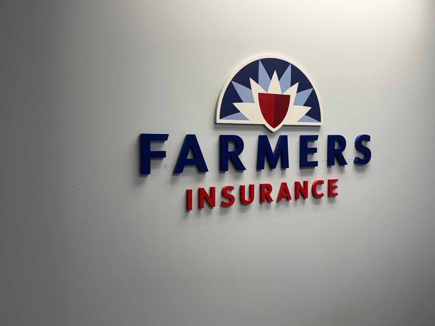 Farmers Insurance logo on a wall, with blue and red text and a shield emblem