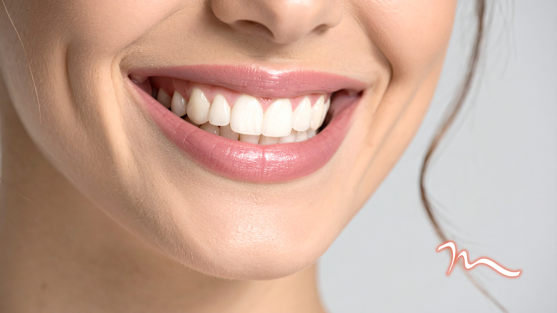 Close-up of a smiling mouth with bright white teeth and pink lips