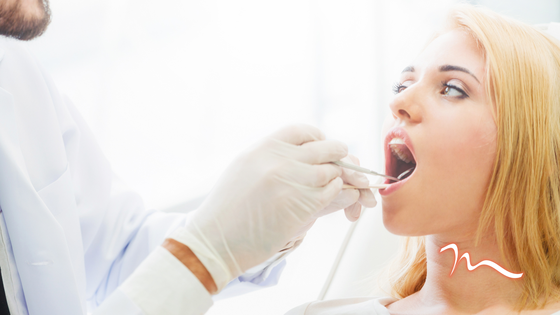Dentist examining open mouth with gloved hand and dental mirror, bright clinic setting