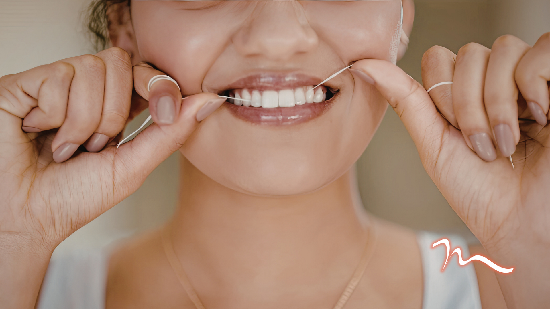 Close-up of a smiling person pulling the corners of their mouth to show white teeth and gums.
