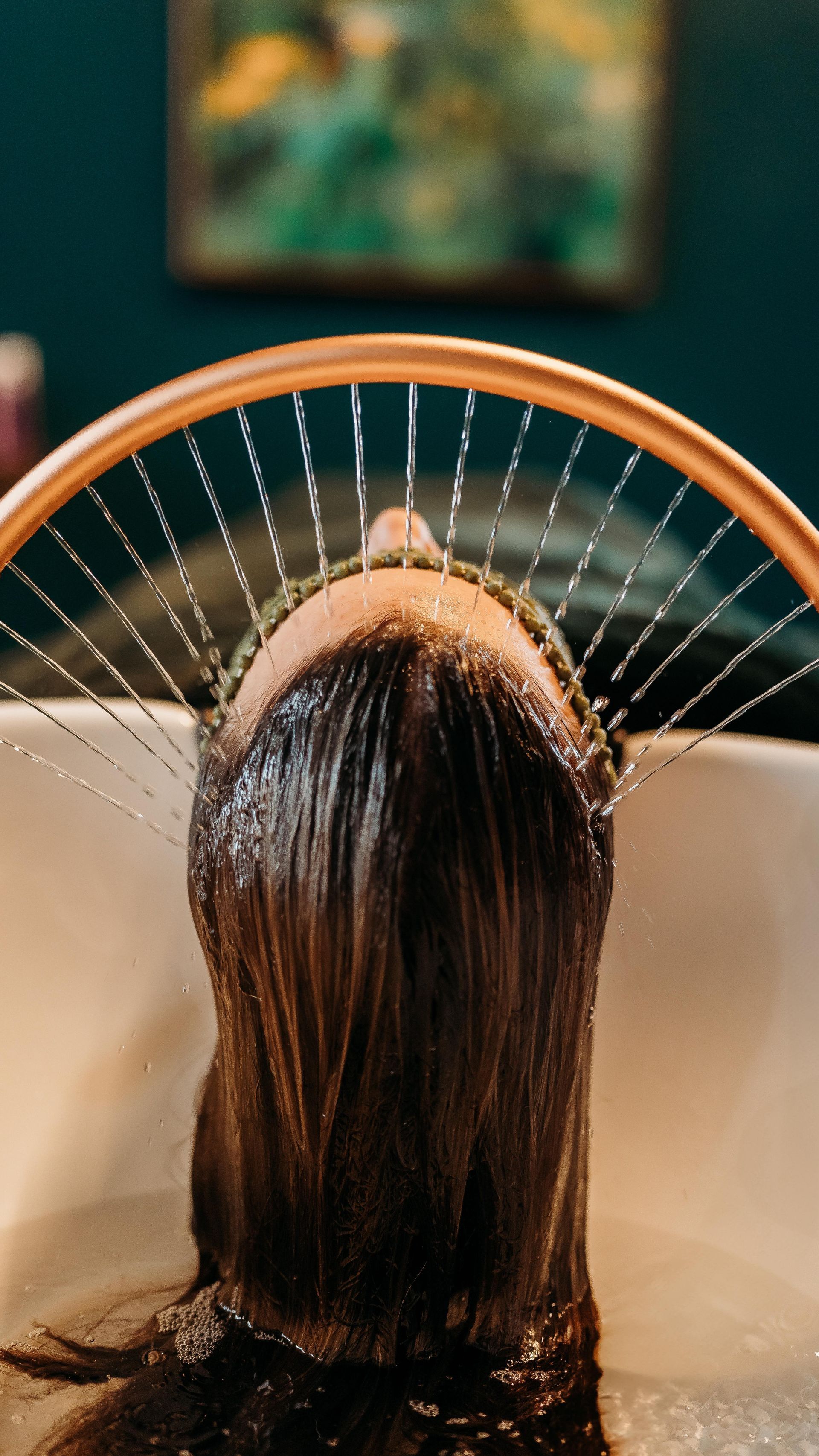 Hair Being Rinsed Under a Salon Sink Spray Arch — Air Hair Studio in Toowoomba City, QLD