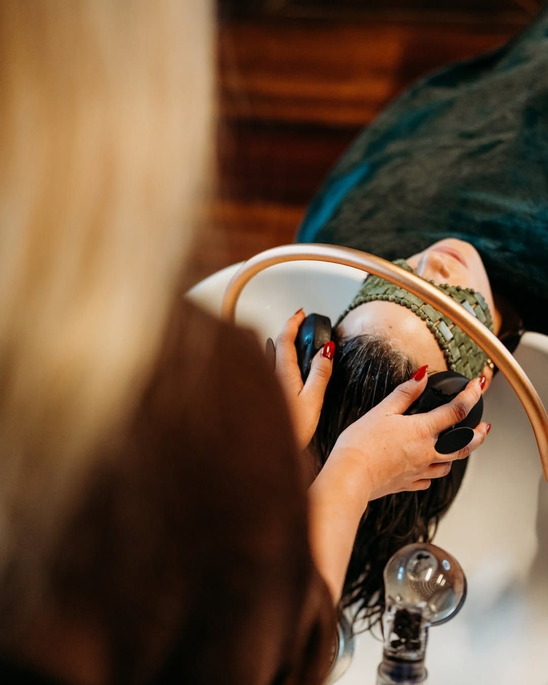 Hair Washing at a Salon, With Hands Rinsing a Person’s Hair Over a Sink — Air Hair Studio in Toowoomba City, QLD