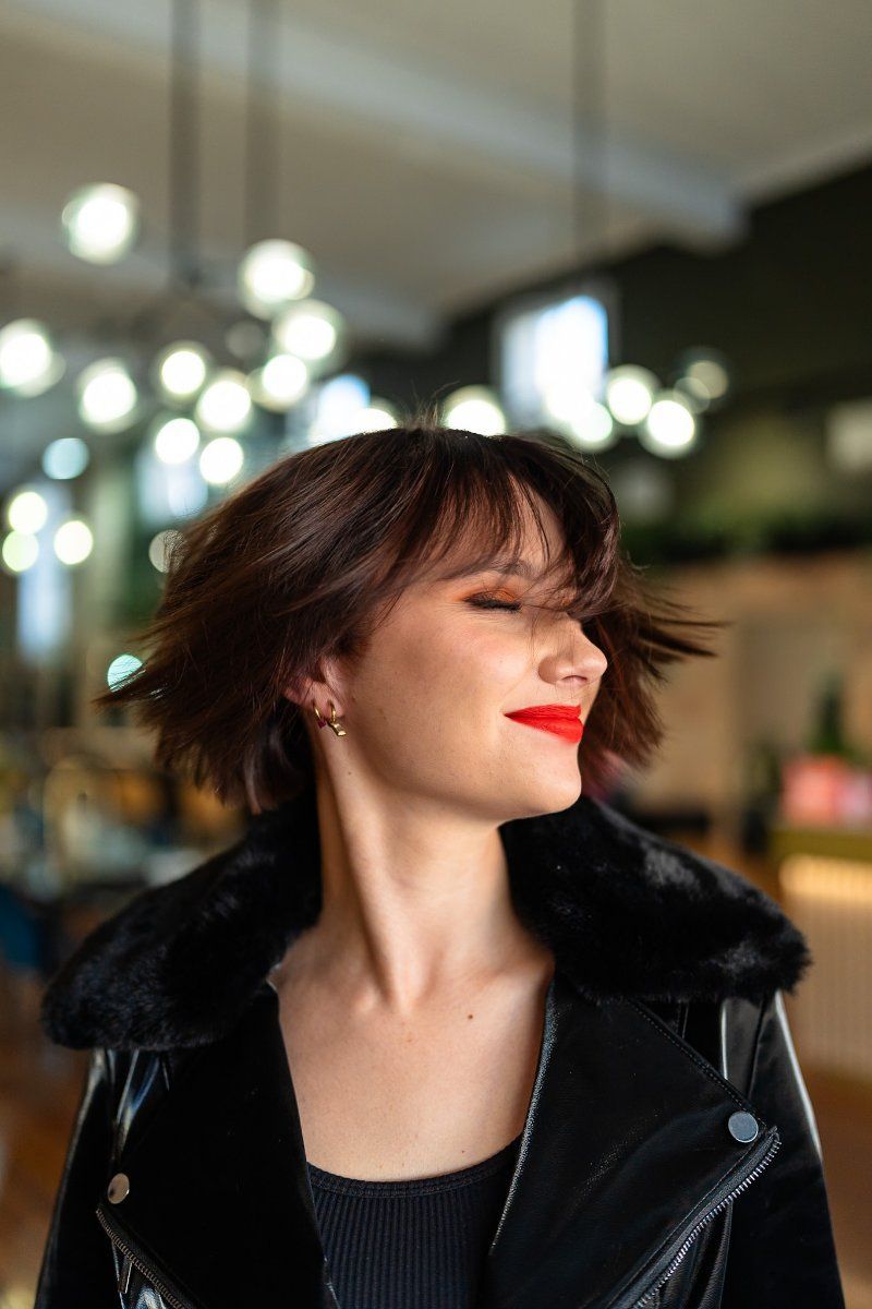 The Woman is Wearing a Black Leather Jacket and Red Lipstick — Air Hair Studio in Toowoomba City, QLD