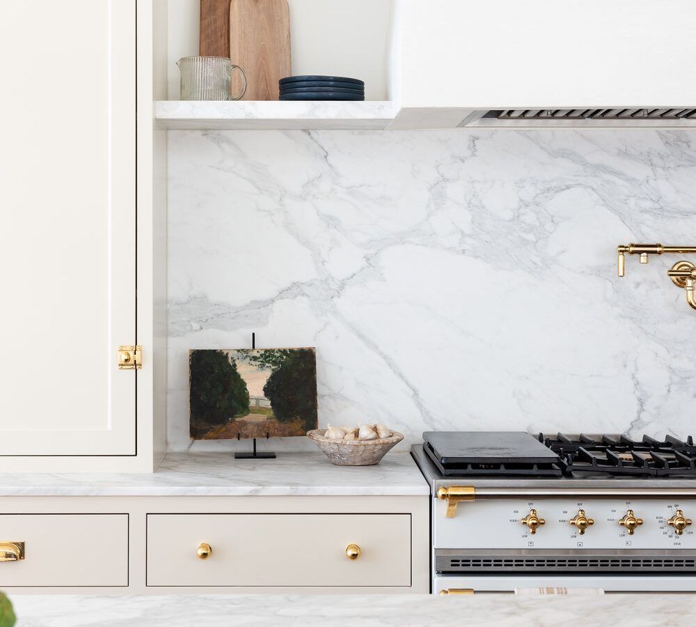 homey kitchen interior with gas stove and white cabinets