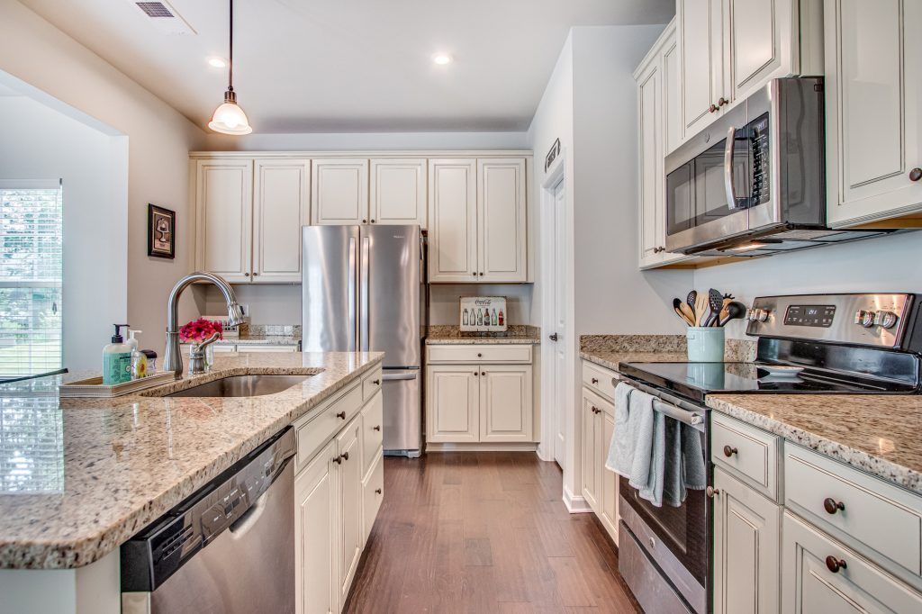 homey kitchen interior with gas stove and white cabinets