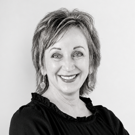 Pam Irvin smiles at the camera in a black sweater