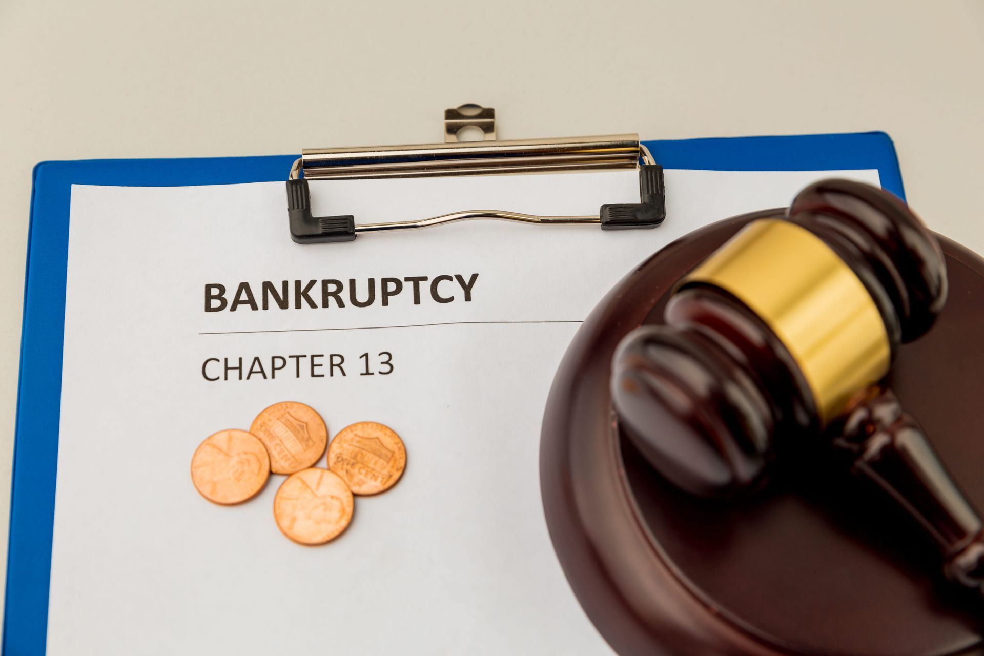 Bankruptcy Chapter 13 document with coins and a judge’s gavel on a clipboard