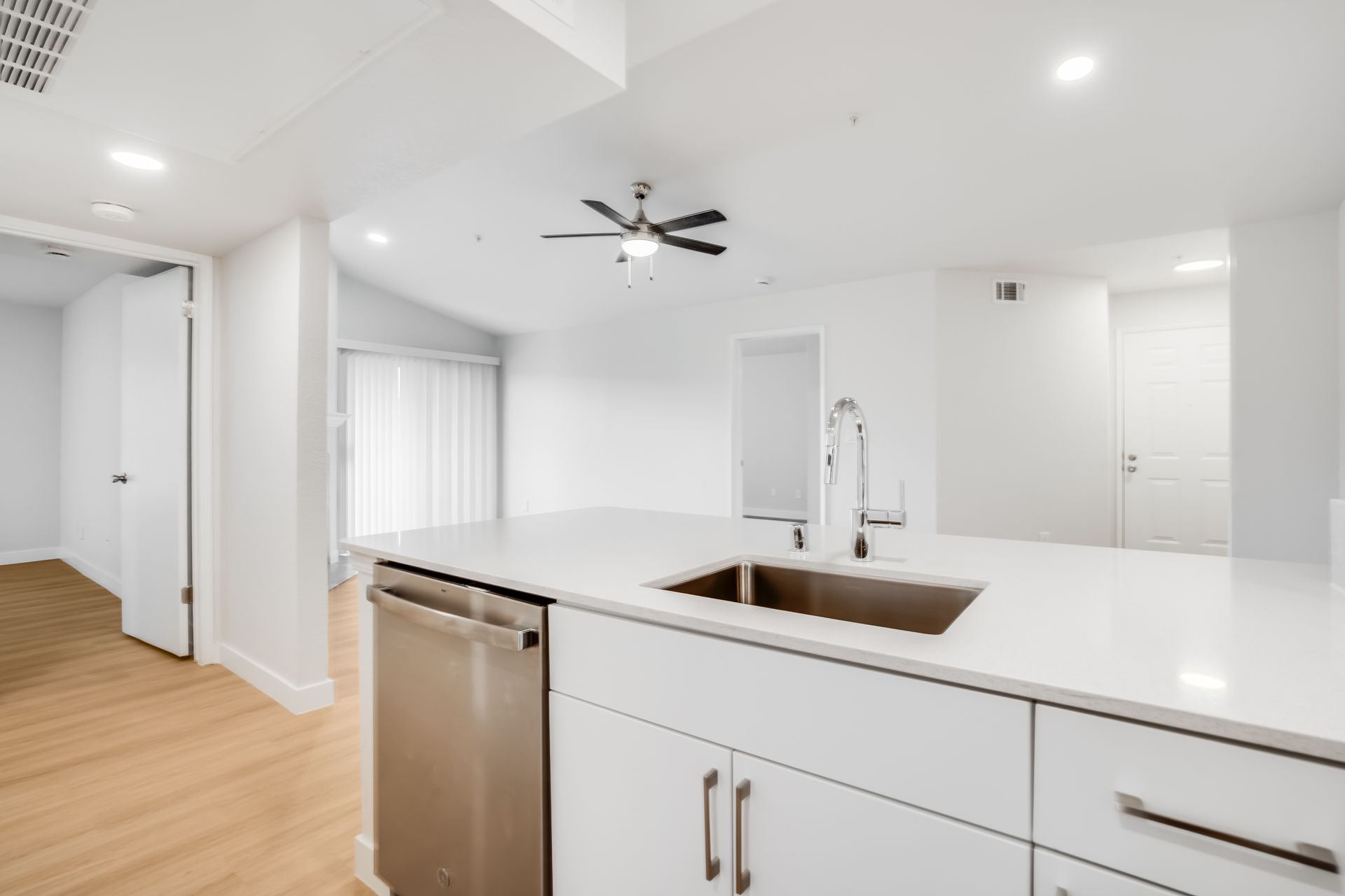 Modern kitchen with white cabinets, stainless steel appliances, and a large island.