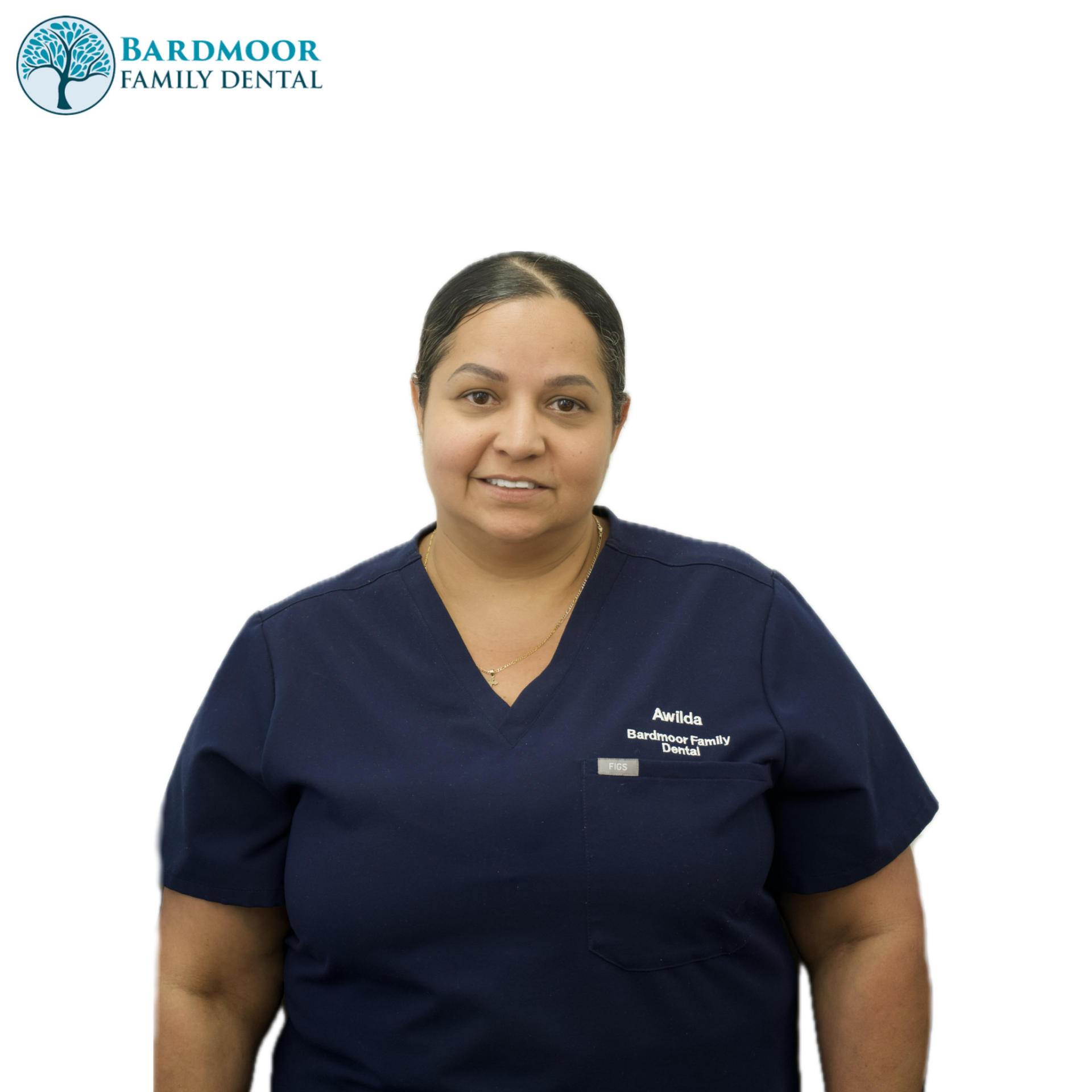 Dental staff member in navy scrubs standing against a white background, smiling.