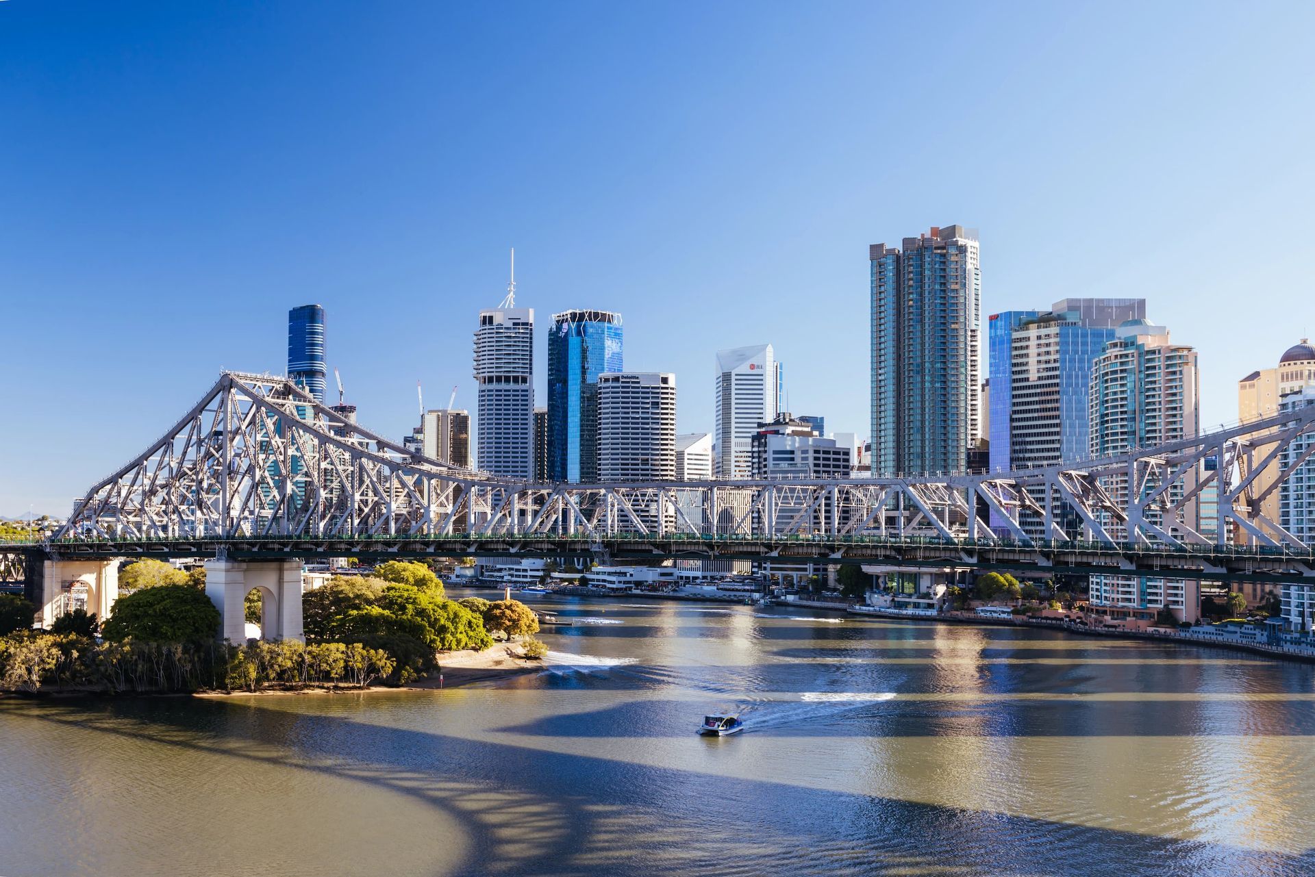 Brisbane skyline and river with ferry going under bridge