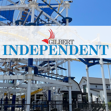 Gilbert Independent sign on a Ferris wheel structure under a blue sky