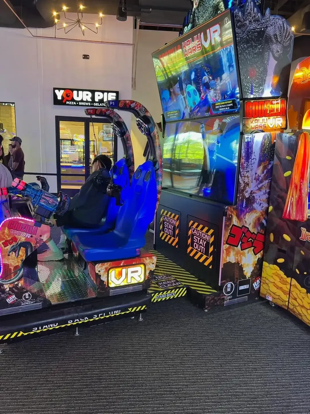 Arcade racing game with two seats, colorful lights, and a large screen showing a driving scene