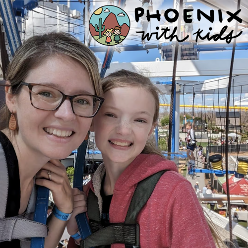 Two smiling people posing at an outdoor ropes course with a “Phoenix with kids” sign.