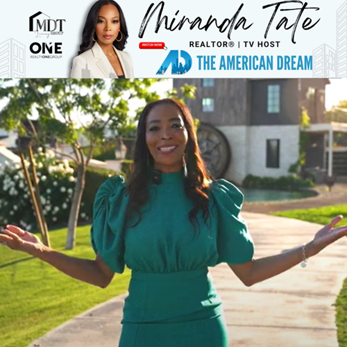 Miranda Tate standing outdoors in a green dress, smiling with arms open on a sunny walkway.