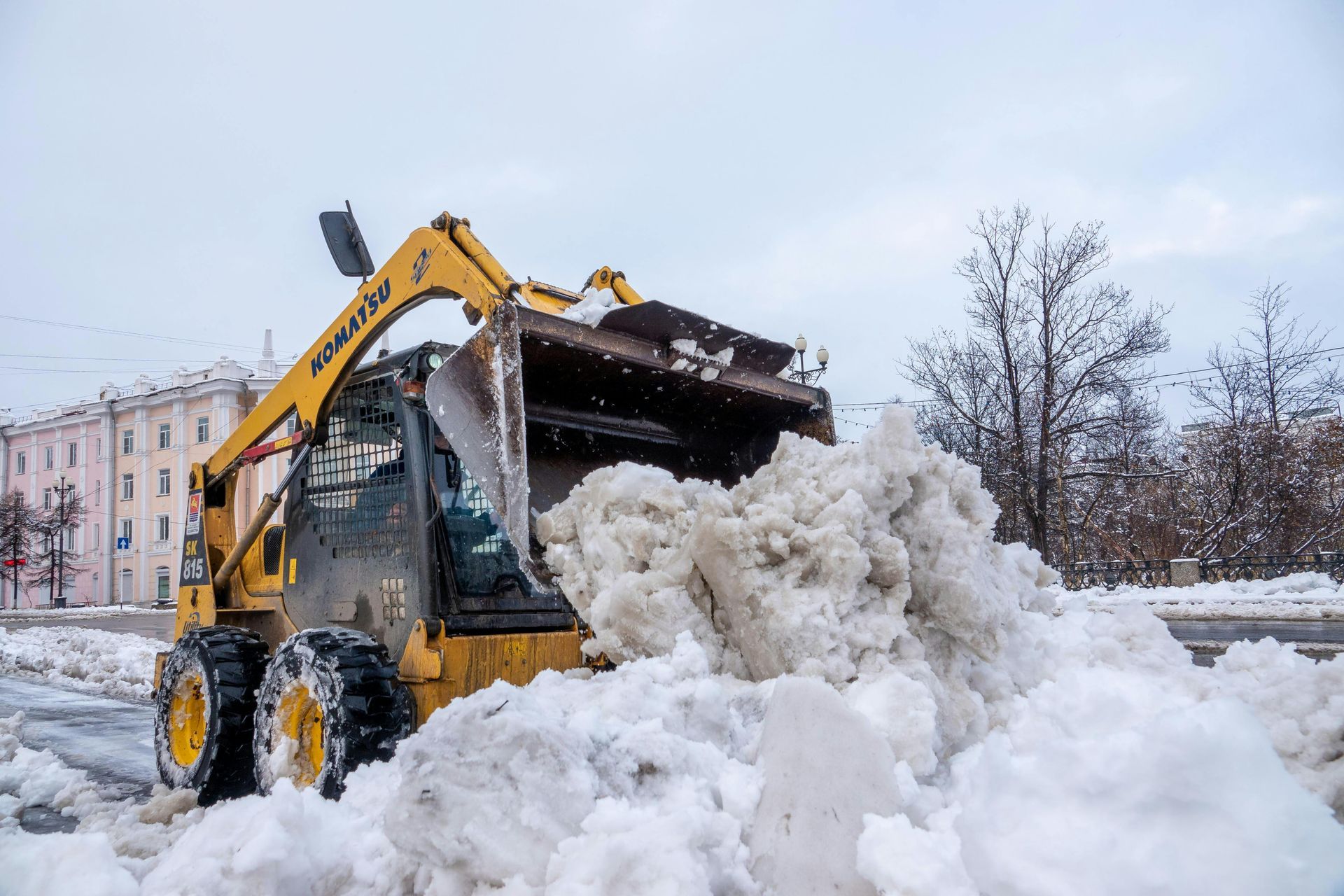 A yellow snow plow is clearing snow from a street.