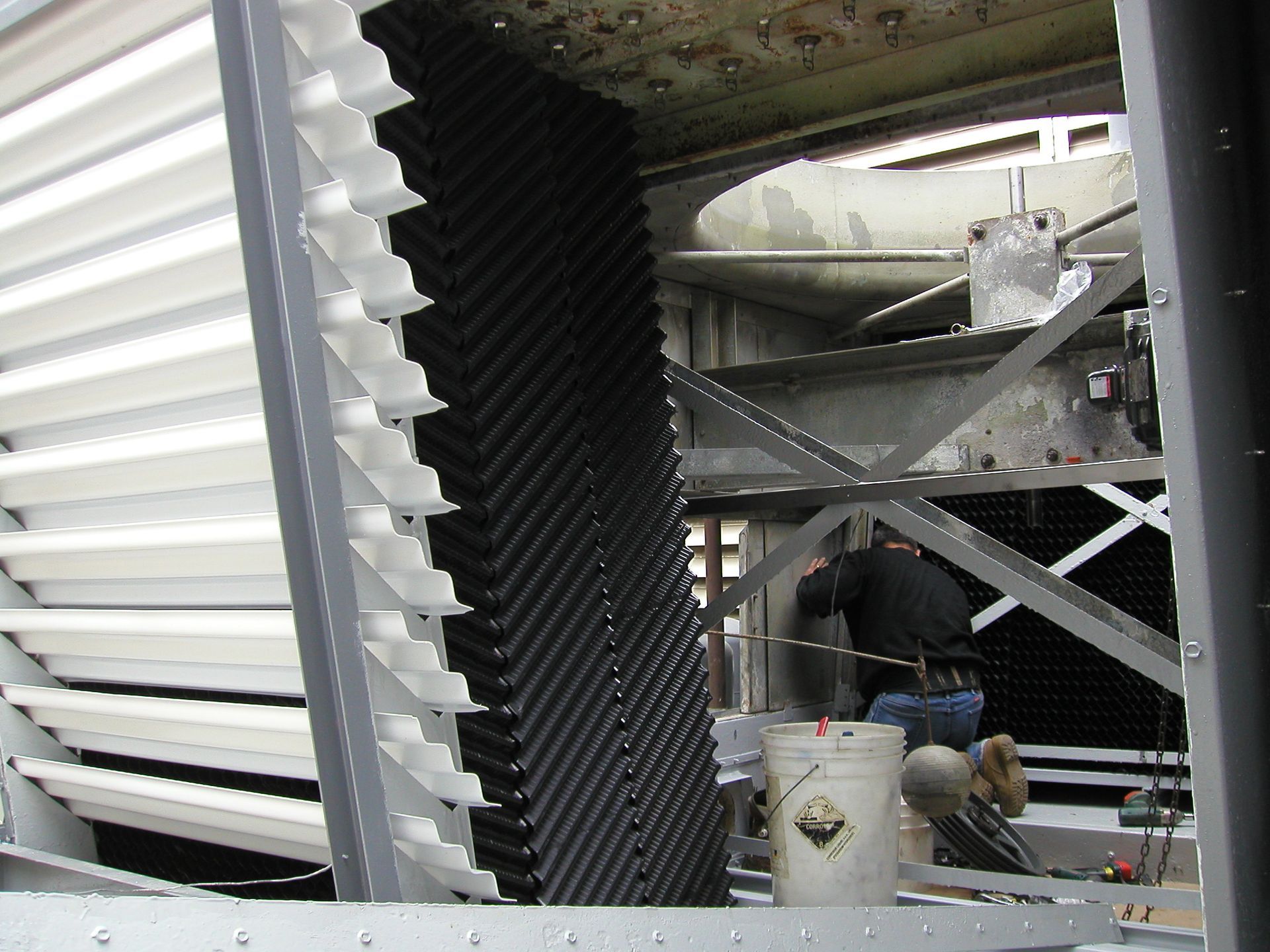 Industrial equipment with large metal louvers and a small work area inside a structure