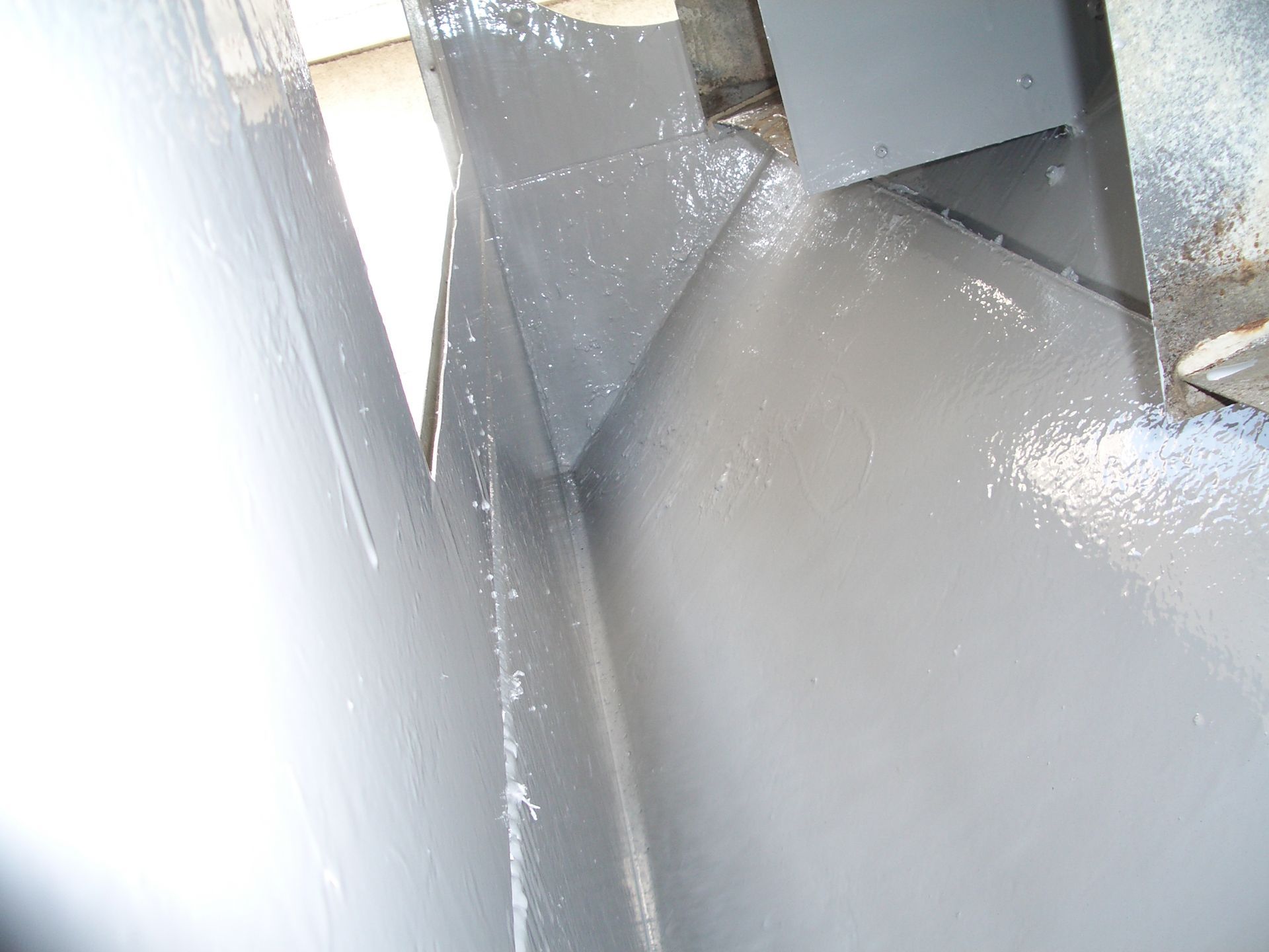 Metal ventilation ducts and pipes in a bright industrial interior.