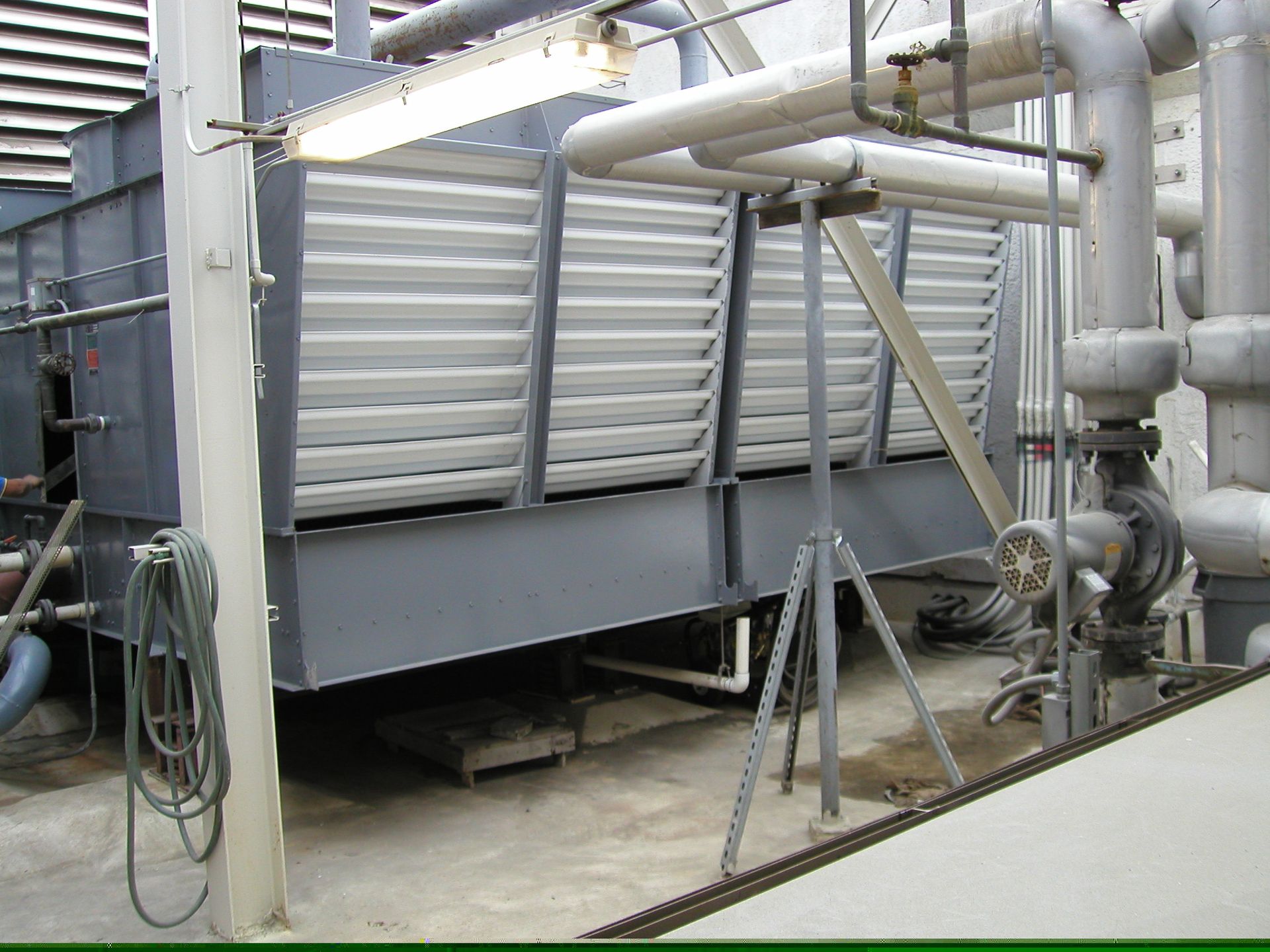 Industrial HVAC unit with silver ductwork and pipes on a rooftop platform