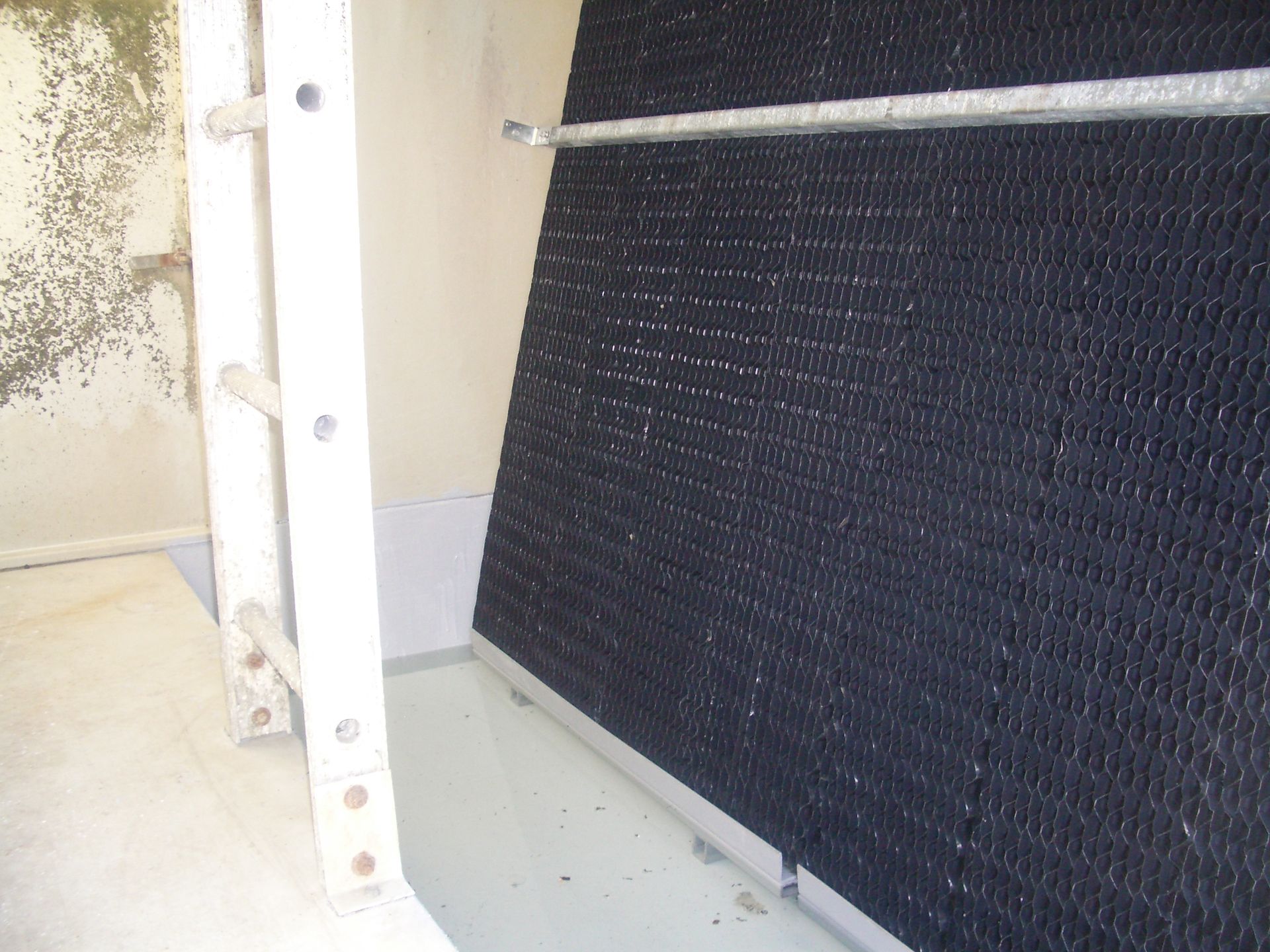 White metal frame beside a black textured panel in an indoor corner