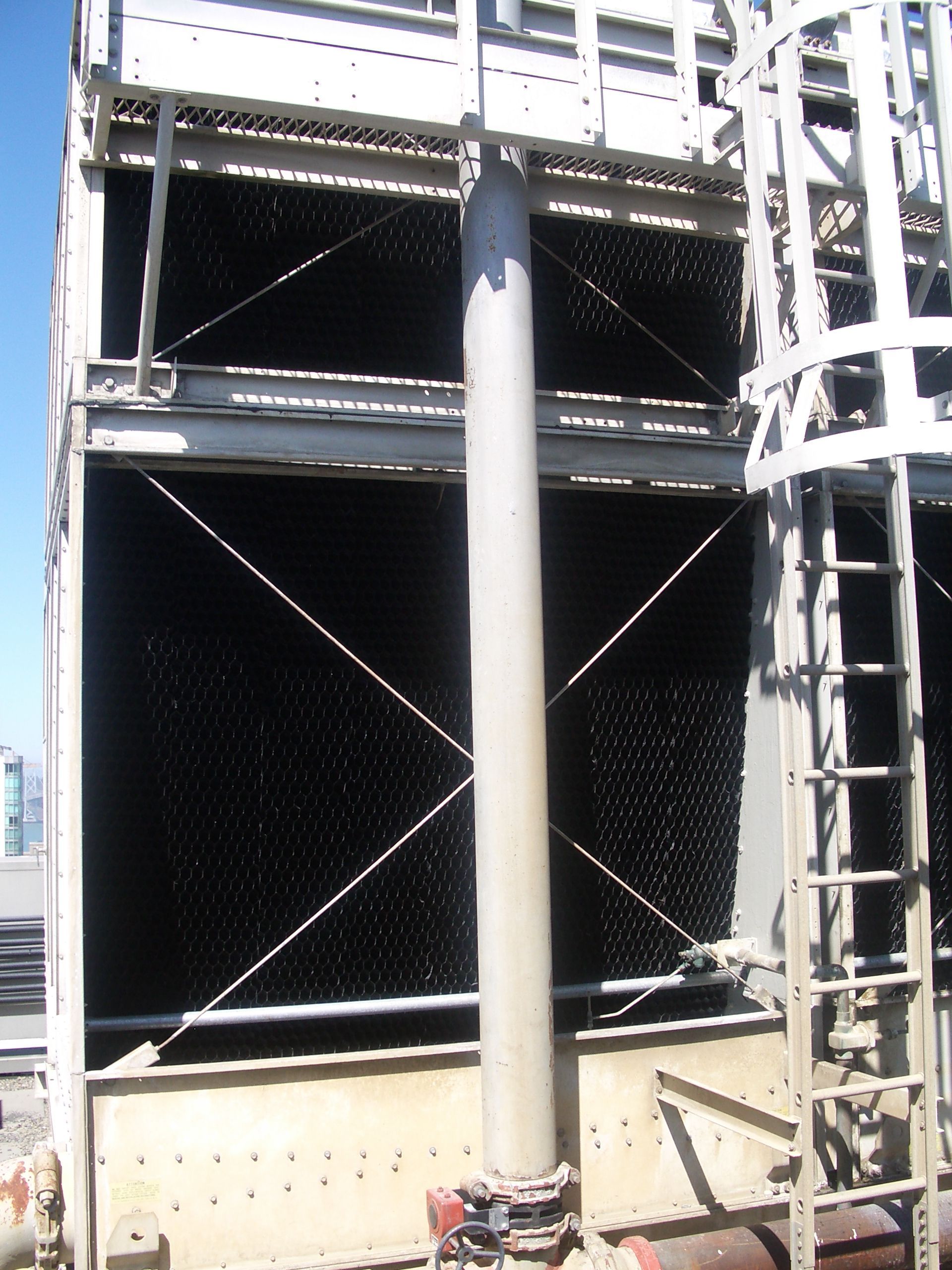 Industrial metal structure with large black panels, cross-bracing, and a central support column
