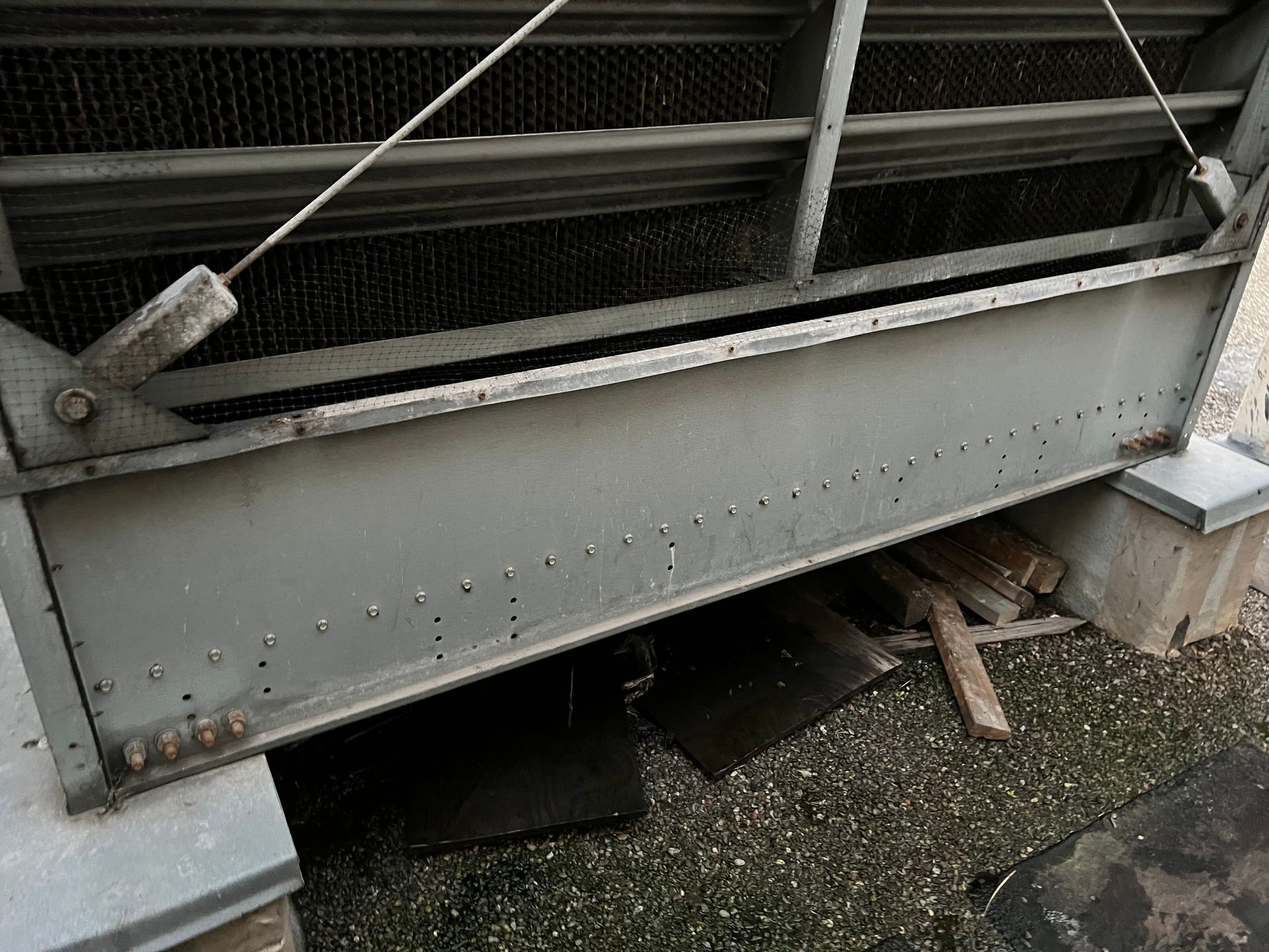 Damaged metal barrier with bent panels and a broken section near the ground