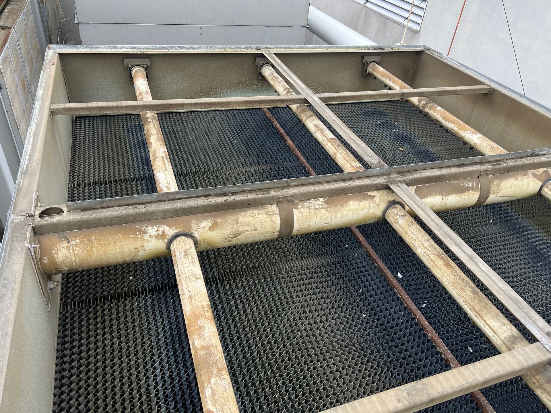 Industrial catwalk with metal grating and pipes inside a utility chamber