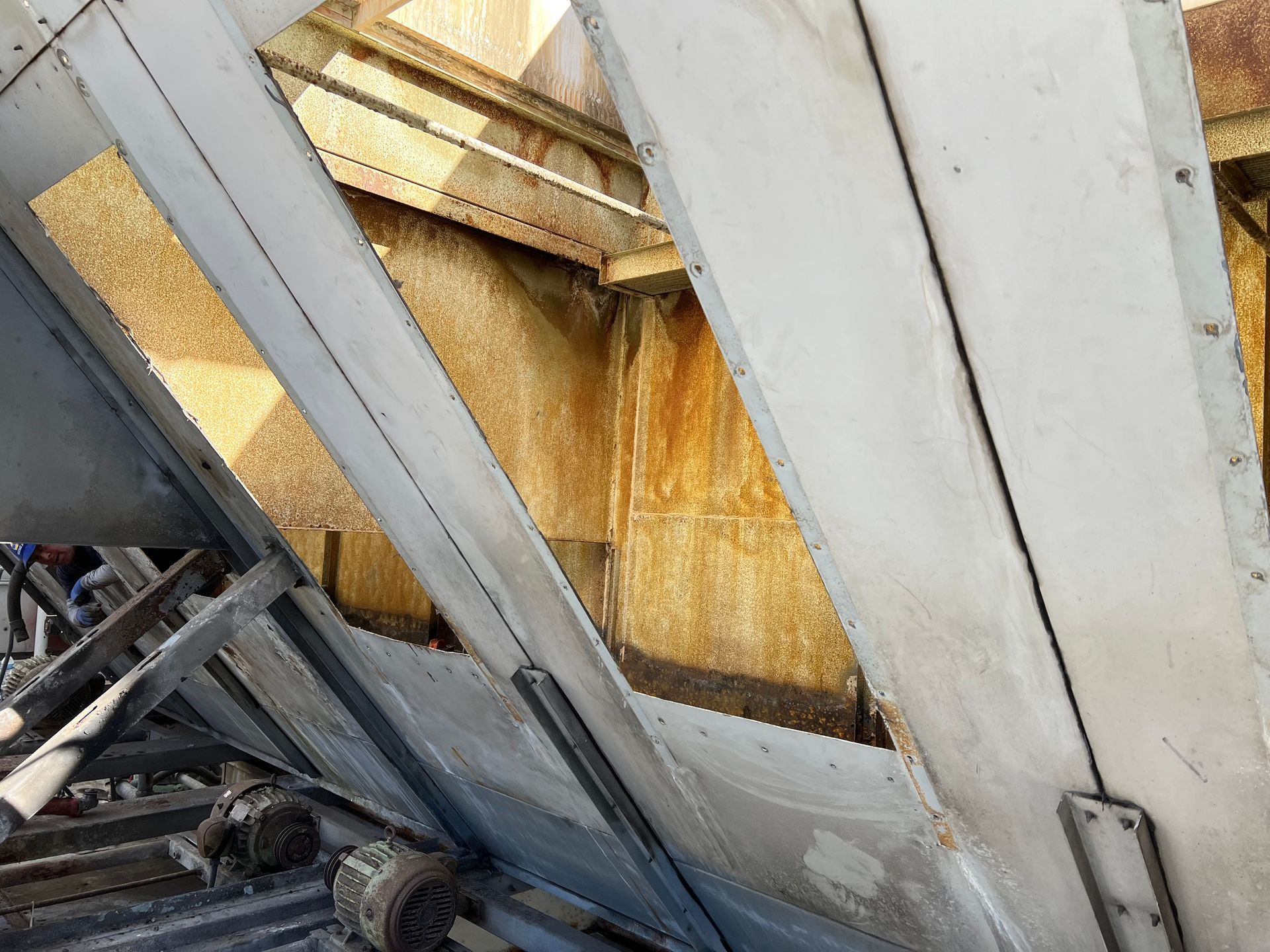 Corroded metal beams and rust-stained wall inside an industrial structure