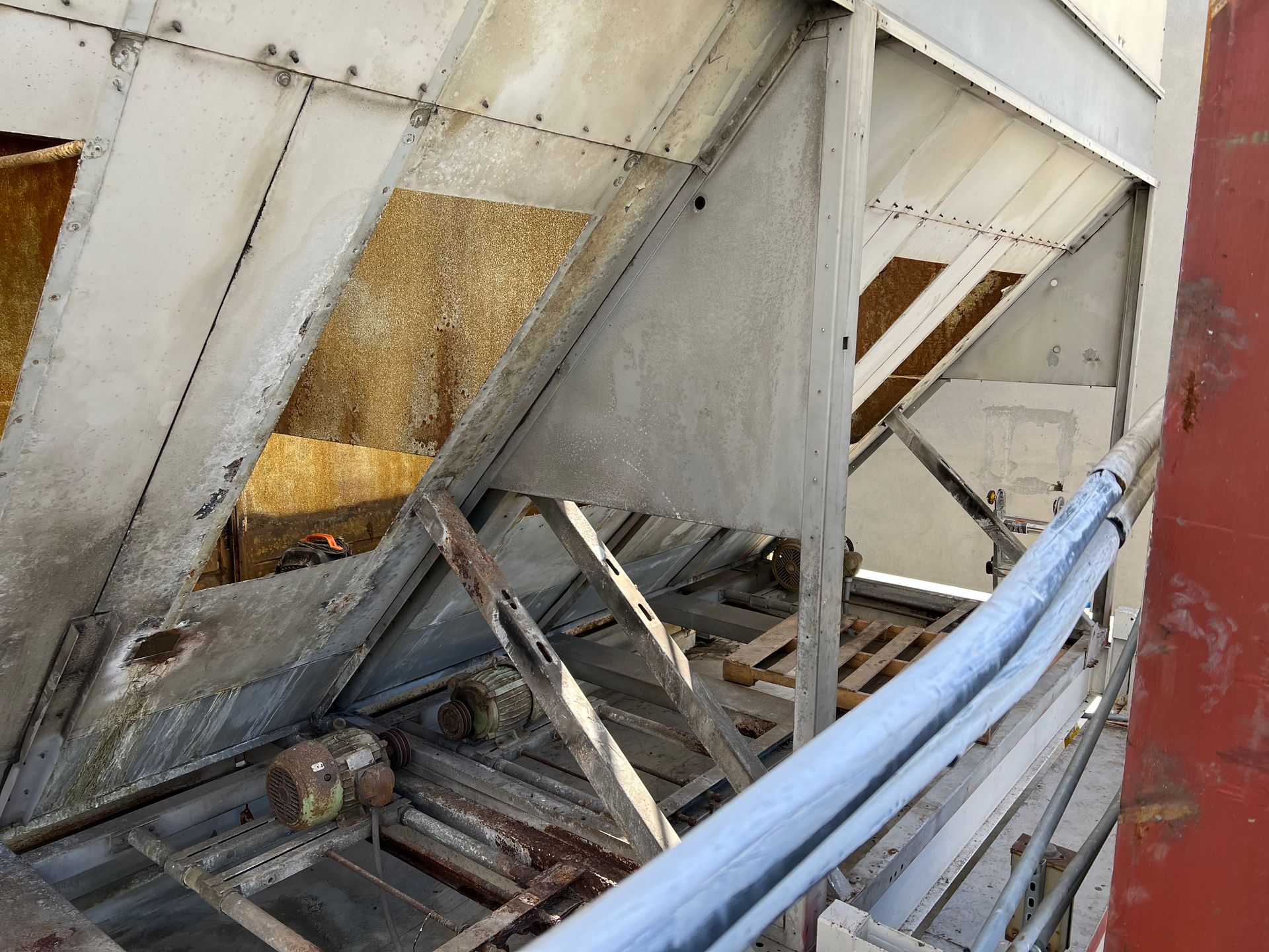 Damaged metal structure with bent beams and debris, showing a collapsed industrial or construction site