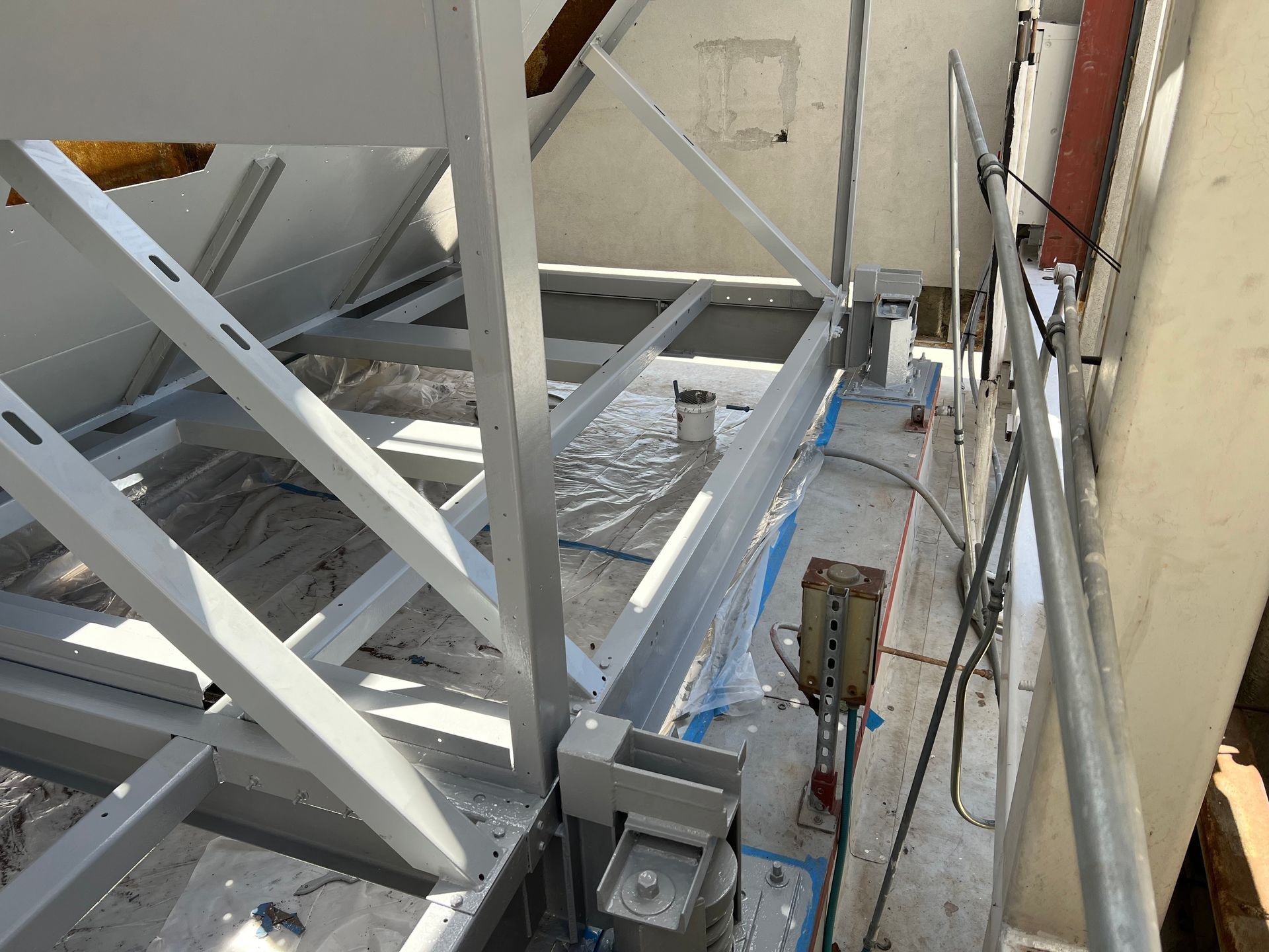 Interior of an industrial structure with steel beams, cables, and a narrow maintenance walkway.