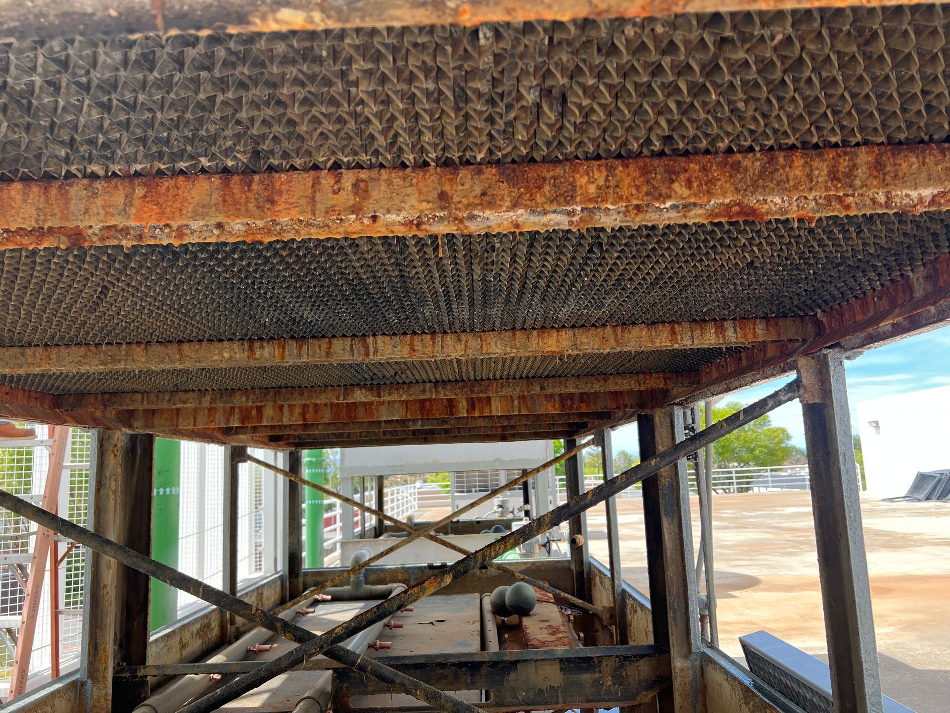 Under a painted scaffold, a worker crawls beneath a building under construction.