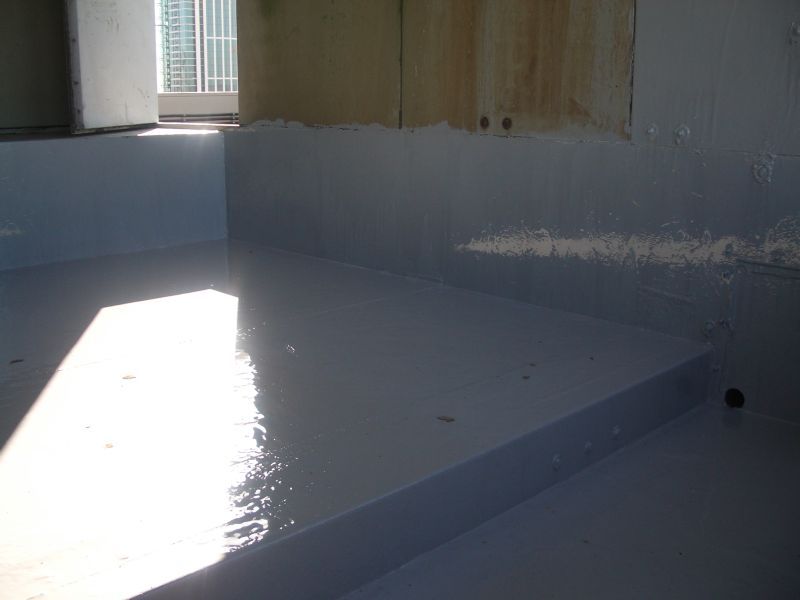 Light blue epoxy-coated floor and walls, possibly a basement, reflecting sunlight.