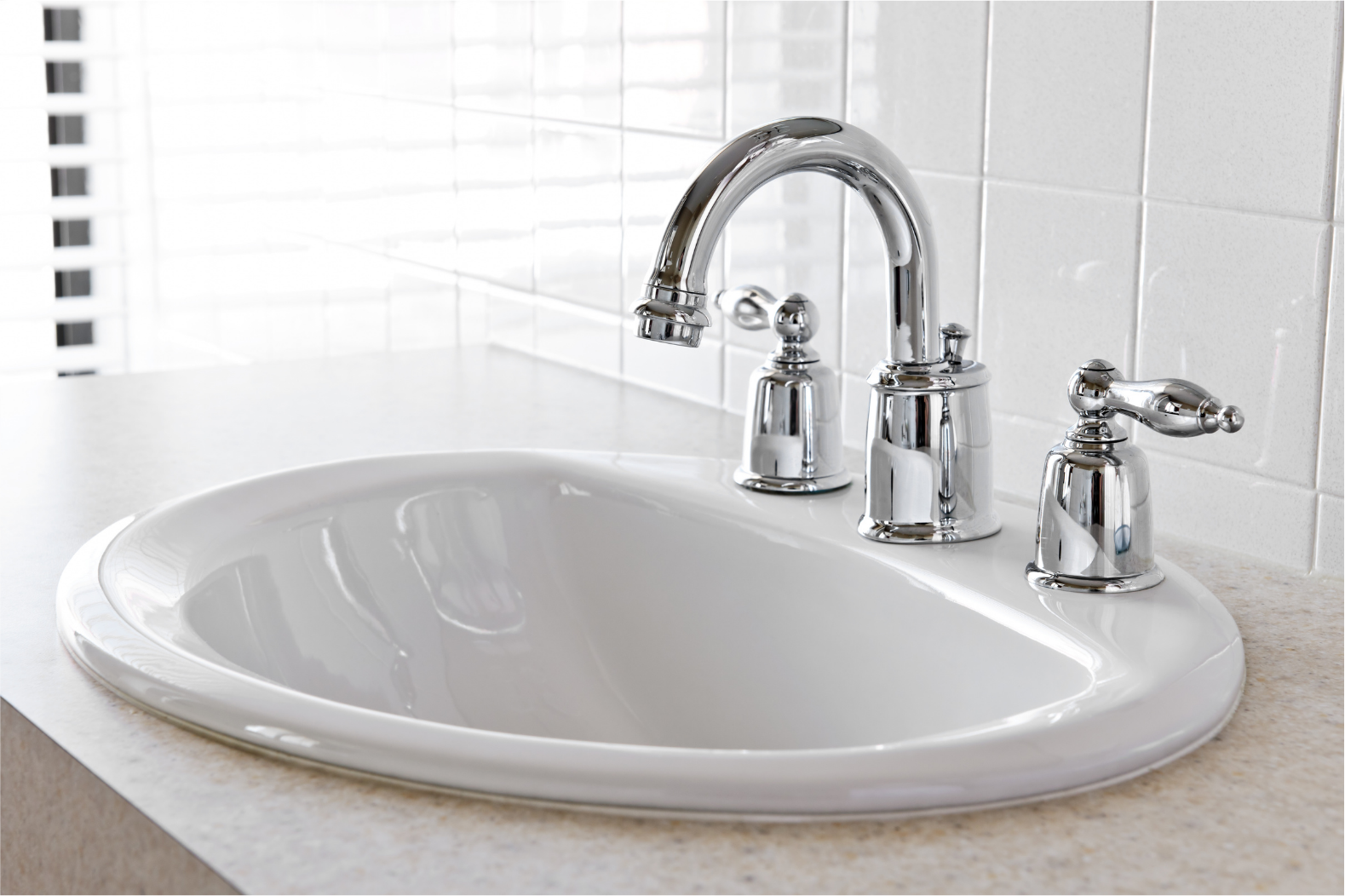 A modern bathroom sink with a polished chrome faucet and two handles.