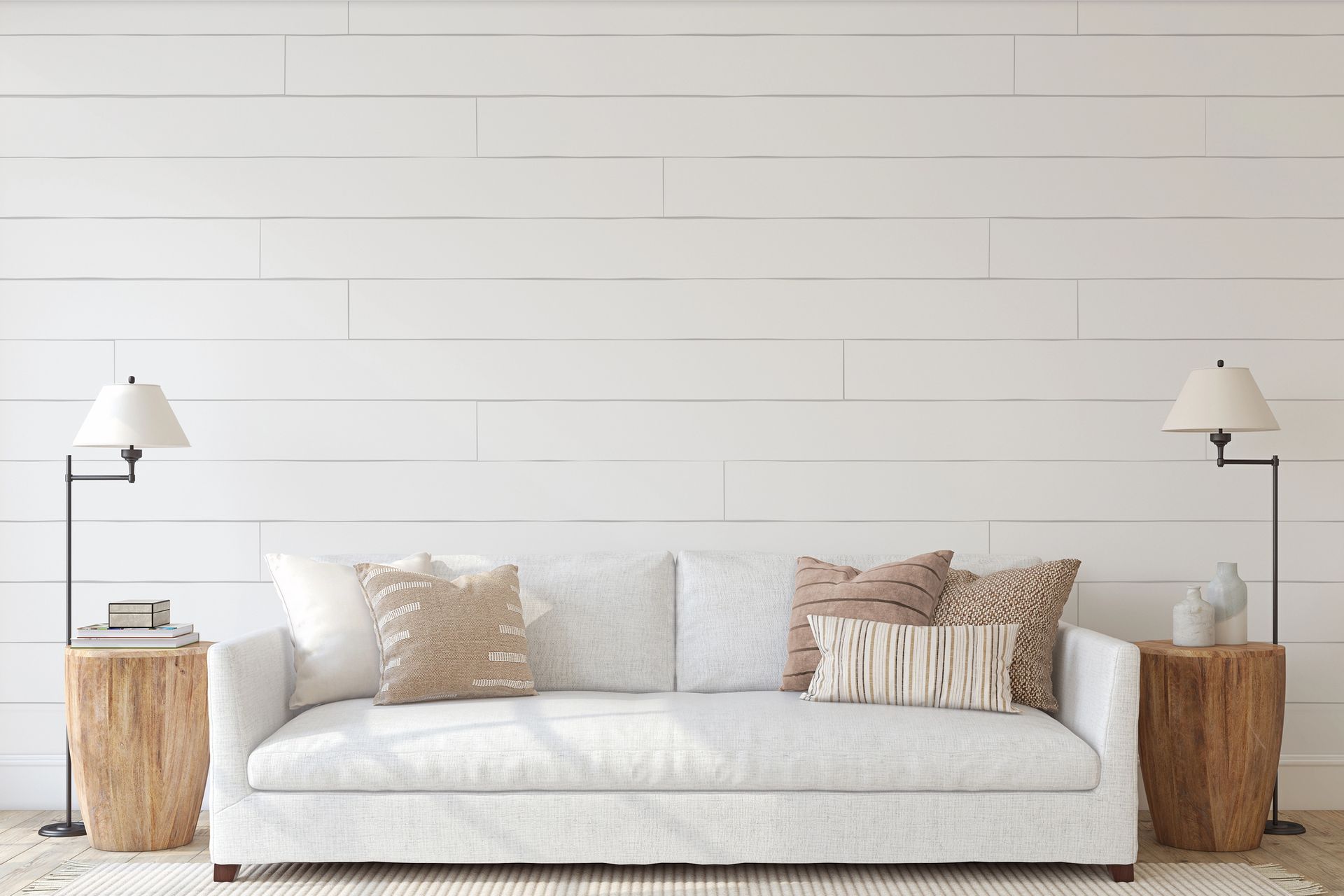 Minimalist living room with a white sofa, neutral pillows, wood side tables, and wall lamps