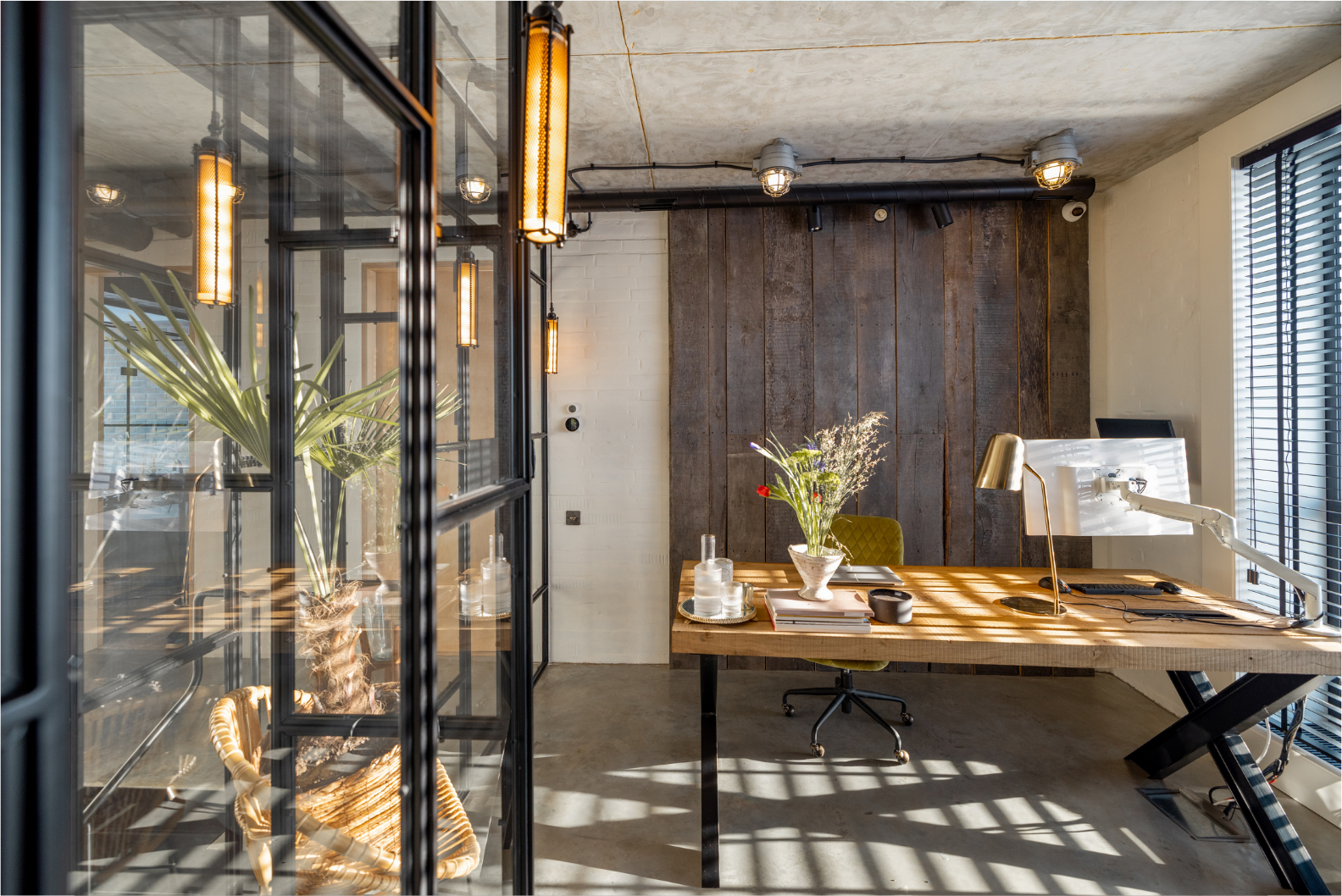 Modern home office with wooden accents, glass walls, and warm lighting.