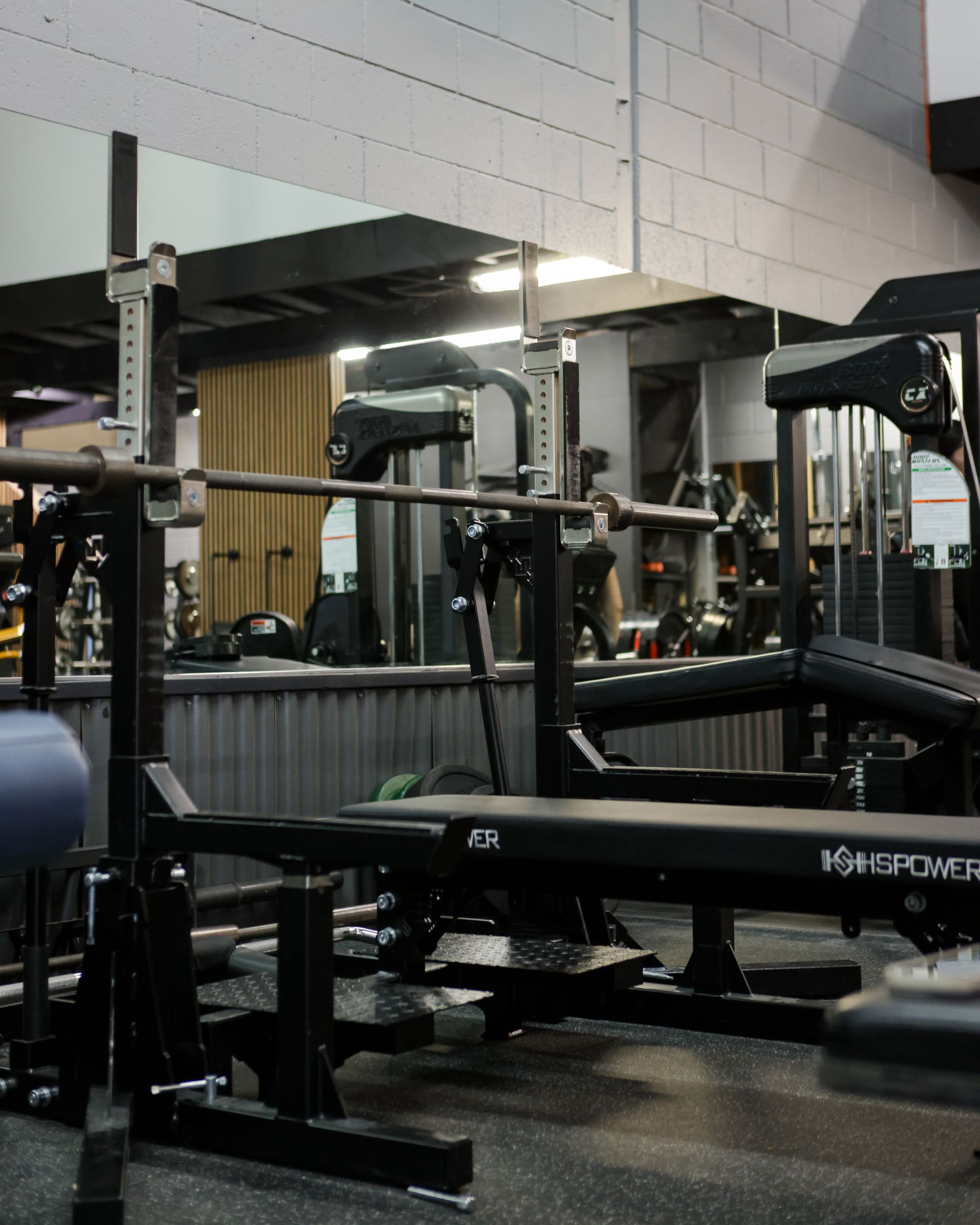 Weightlifting bench with barbell in a gym.