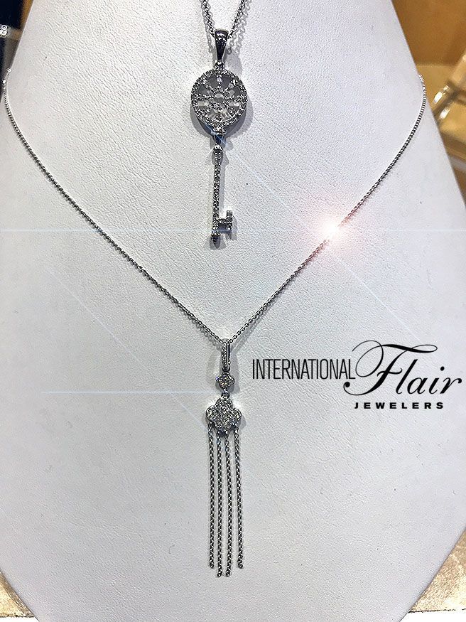 A necklace with a key pendant is on a mannequin.